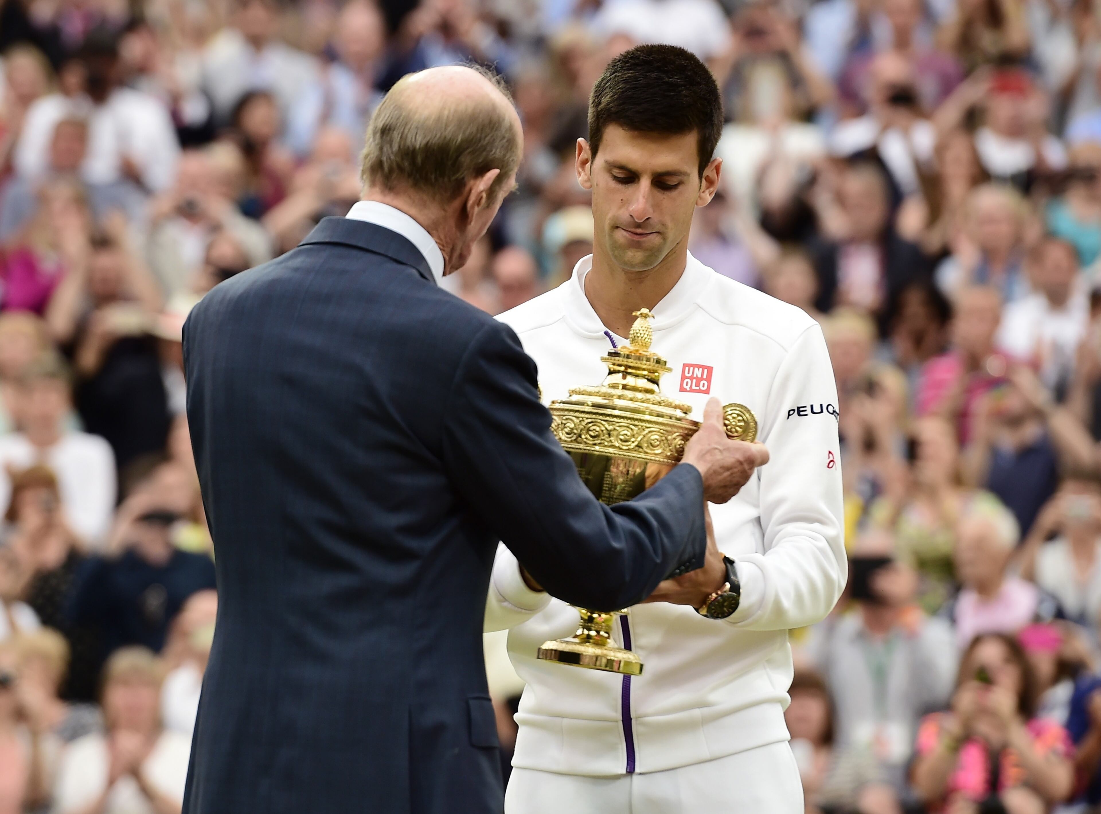 LONDON, ENGLAND - JULY 12: Novak Djokovic of Serbia is presented with the trophy by Prince Edward, Duke of Kent after victory over Roger Federer of Switzerland in the Final of the Gentlemen's Singles on day thirteen of the Wimbledon Lawn Tennis Championships at the All England Lawn Tennis and Croquet Club on July 12, 2015 in London, England. (Photo by Alex Broadway/Anadolu Agency/Getty Images)