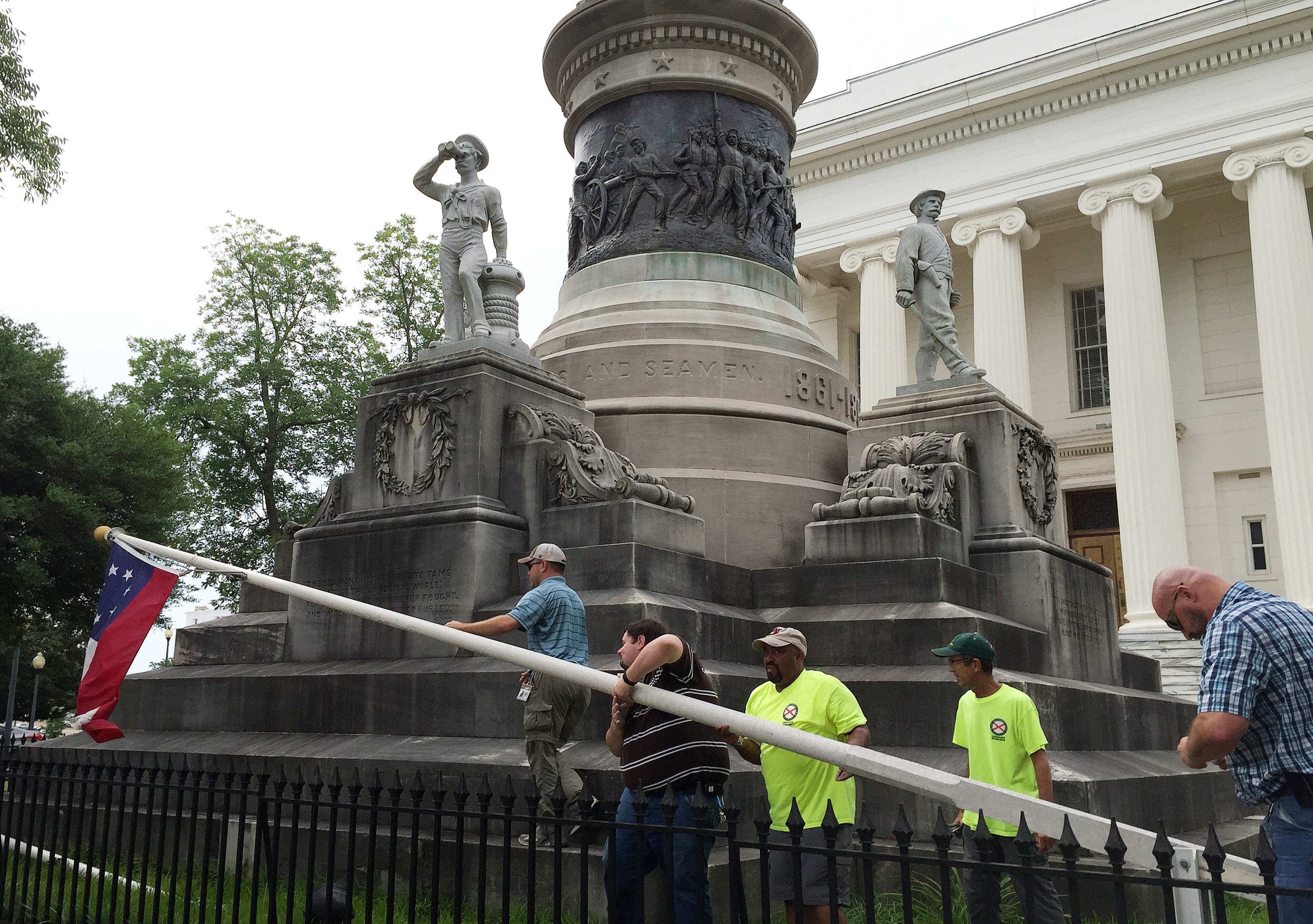 State workers take down a Confederate national flag on the grounds of the state Capitol, Wednesday, June 24, 2015, in Montgomery. Alabama Gov. Robert Bentley orders Confederate flags taken down from state Capitol. (AP Photo/Martin Swant)