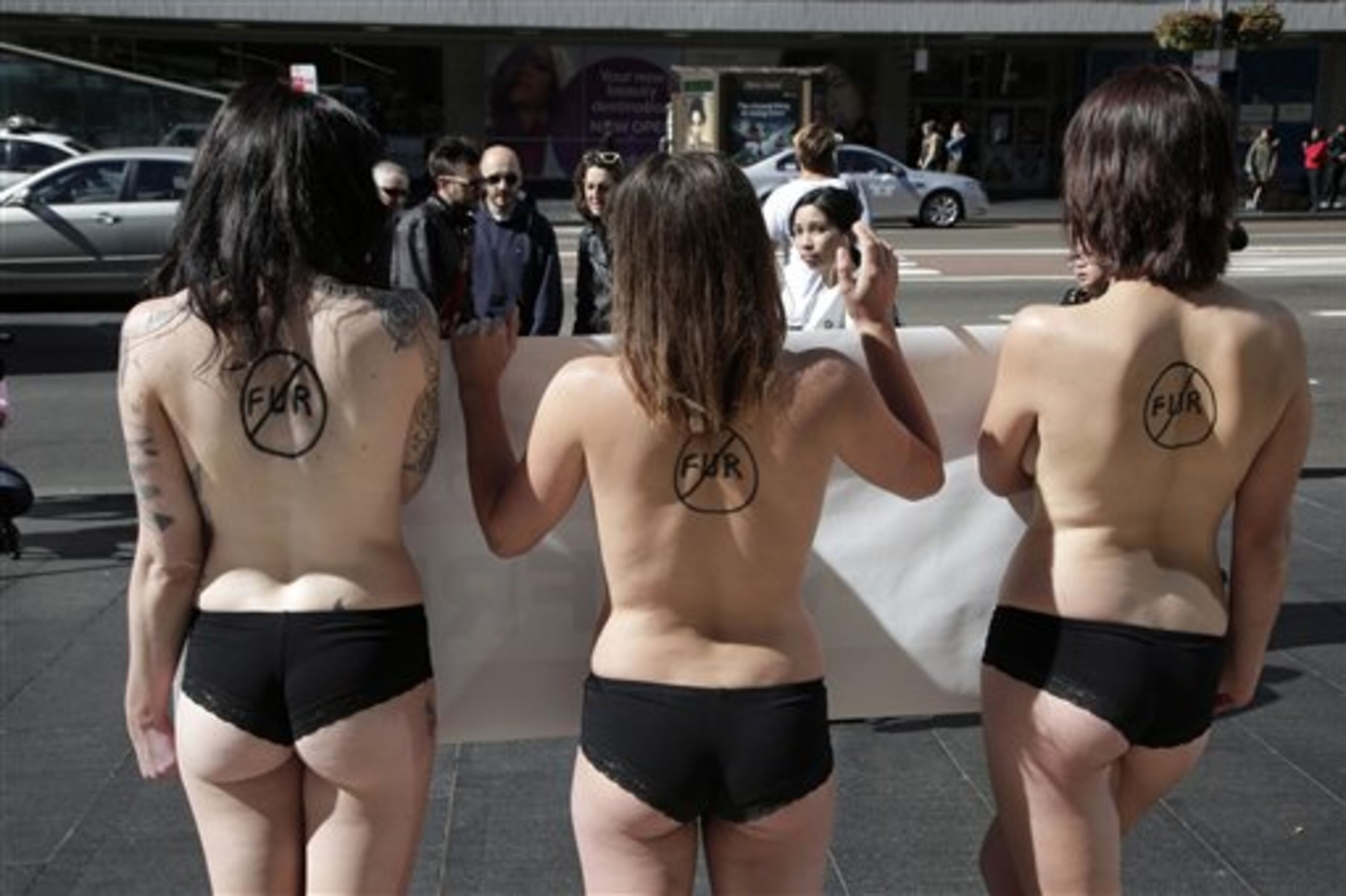 Anti-fur protesters Tanya Ward, right, Zoe Crawford and Jacqui House, left, strip to their underwear in an attempt to persuade clothing designers to stop using animal fur in Sydney, Australia, Wednesday, Aug. 21, 2013. The protestors from PETA, People for the Ethical Treatment of Animals, are protesting at Sydney Town Hall where a fashion festival is set to begin. (AP Photo/Rick Rycroft)