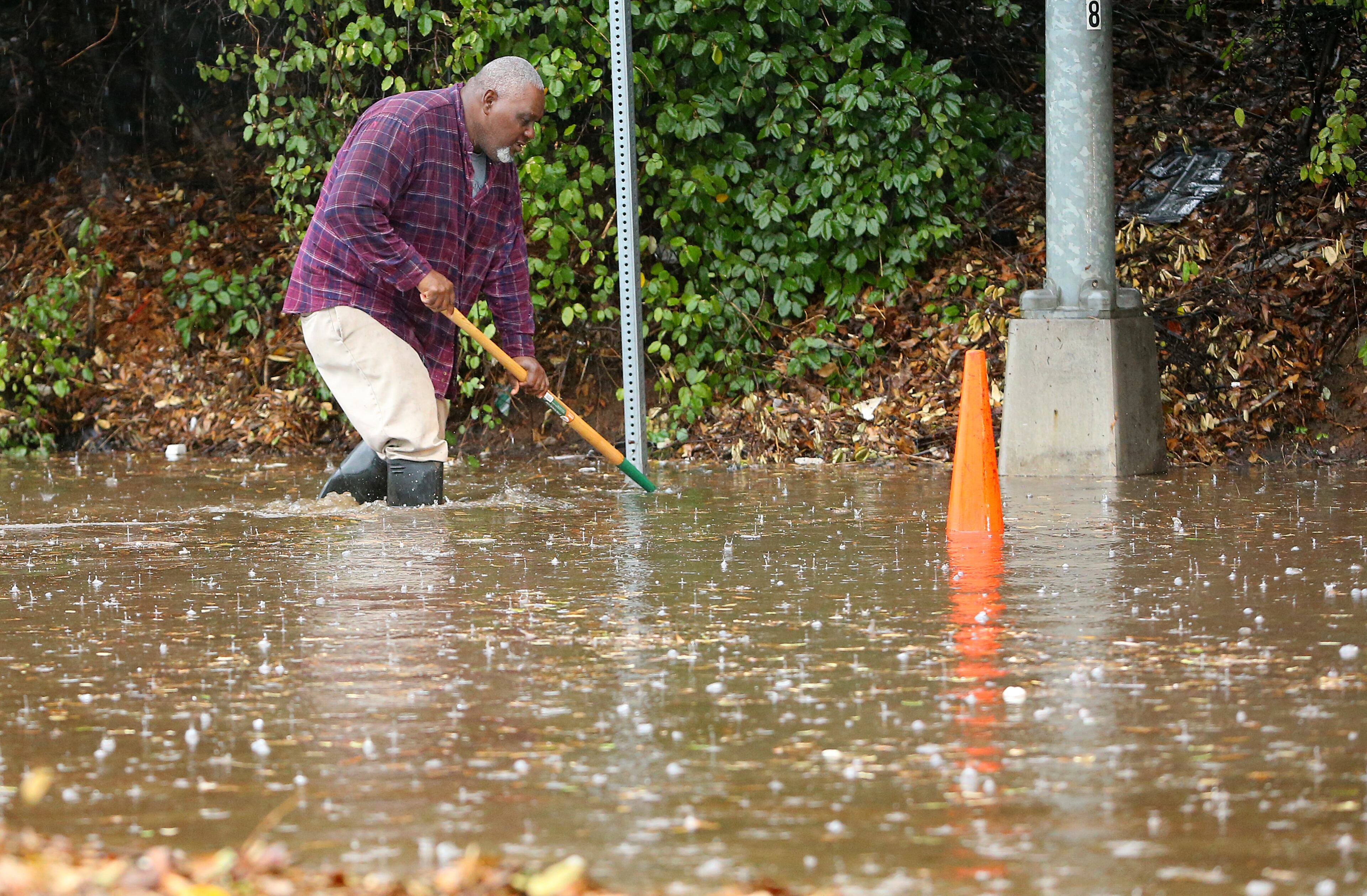 The Hill Street-Turner Field exit ramp at I-20 West is closed from flooding while DOT worker Mike Gousha works in knee-deep water to clear storm drains on Dec. 22, 2013, in Atlanta.