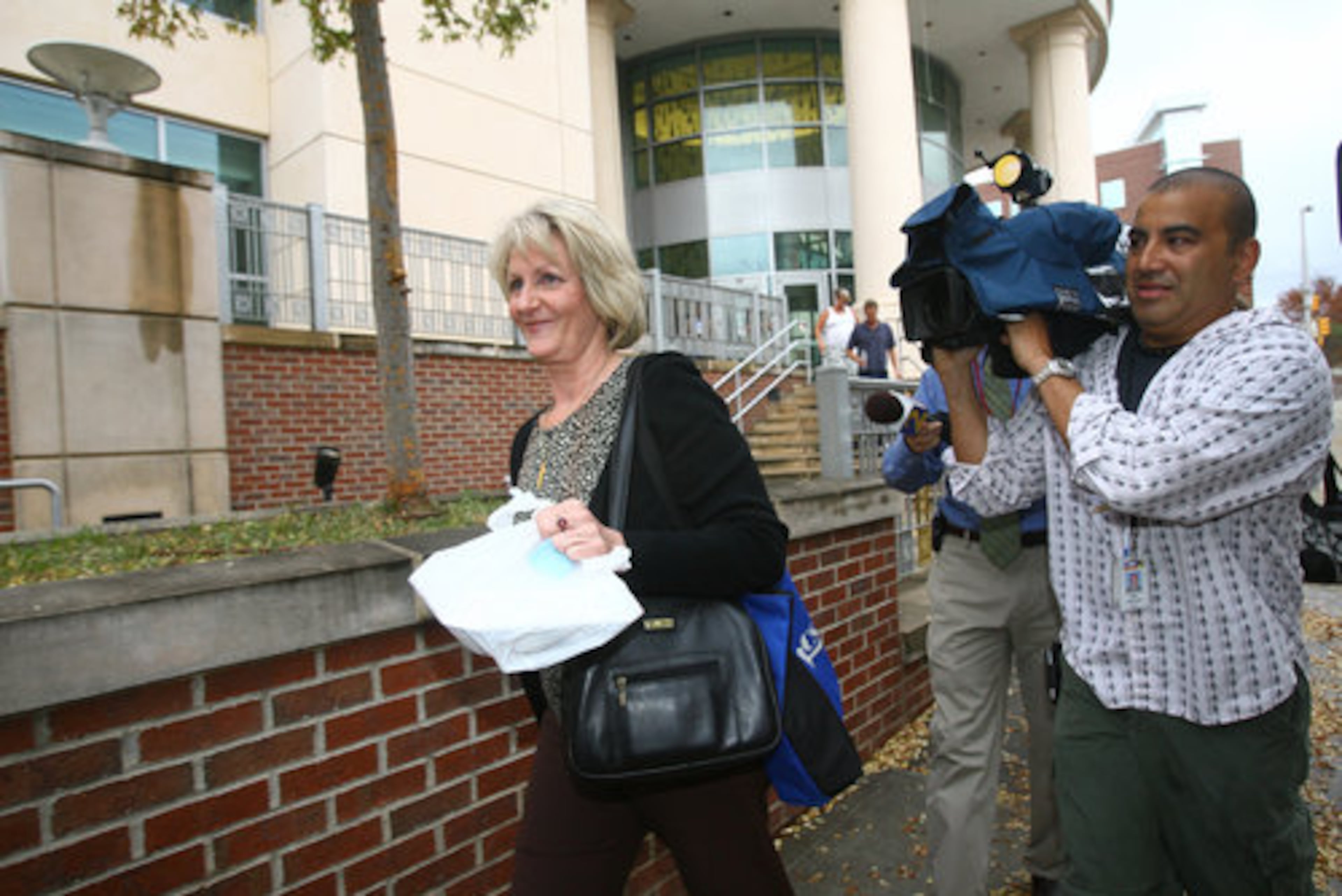 Claudia Barnes, widow of Judge Rowland Barnes, is followed by cameras after the verdict was announced.