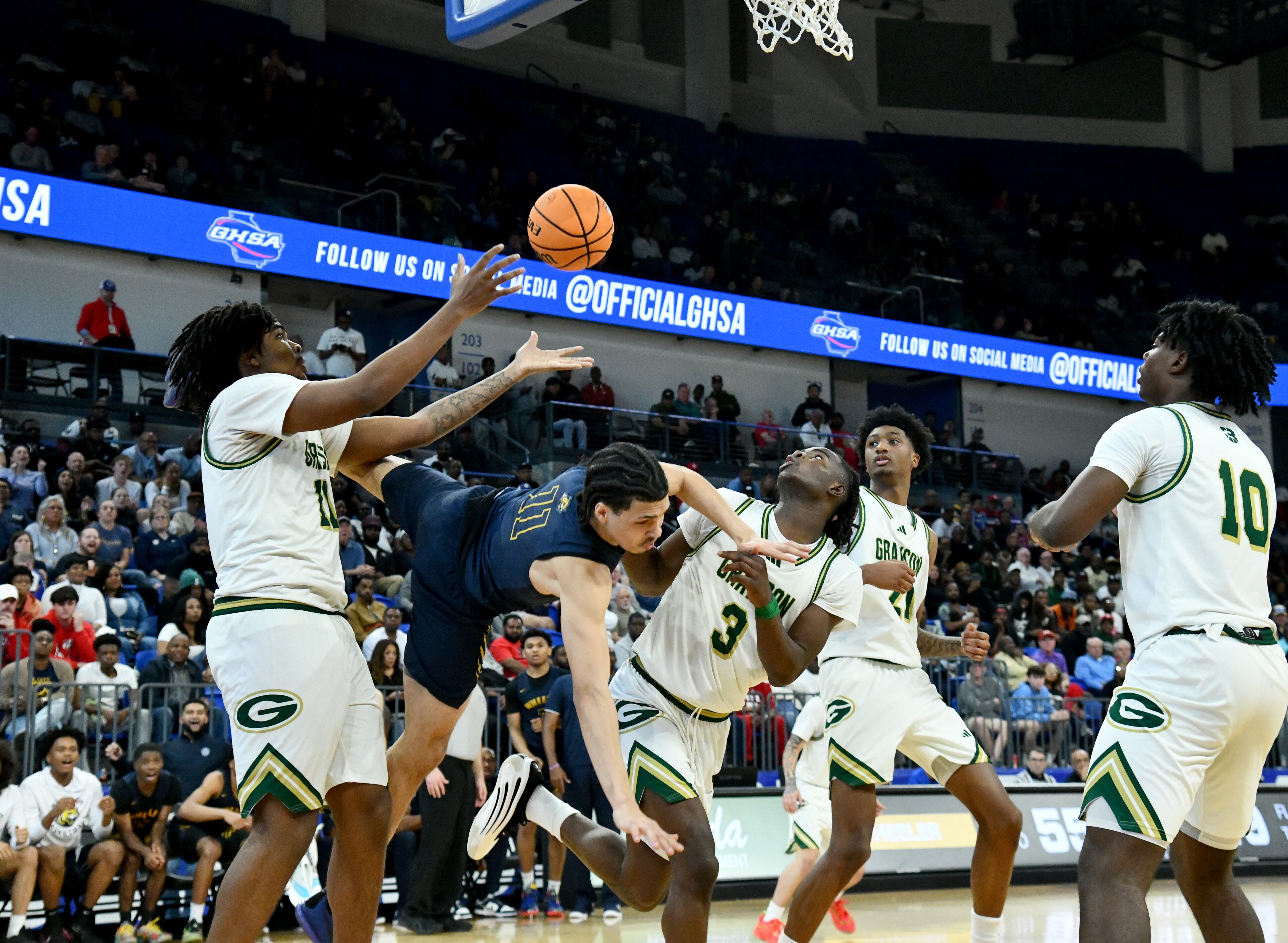 Wheeler's Amare James (11) falls as he fights for a rebound during the second half of the GHSA Class 6A Boys State Basketball playoffs game at the Georgia State Convocation Center, Saturday, March 1, 2025, in Atlanta. Wheeler won 68-53 over Grayson. (Hyosub Shin / AJC)