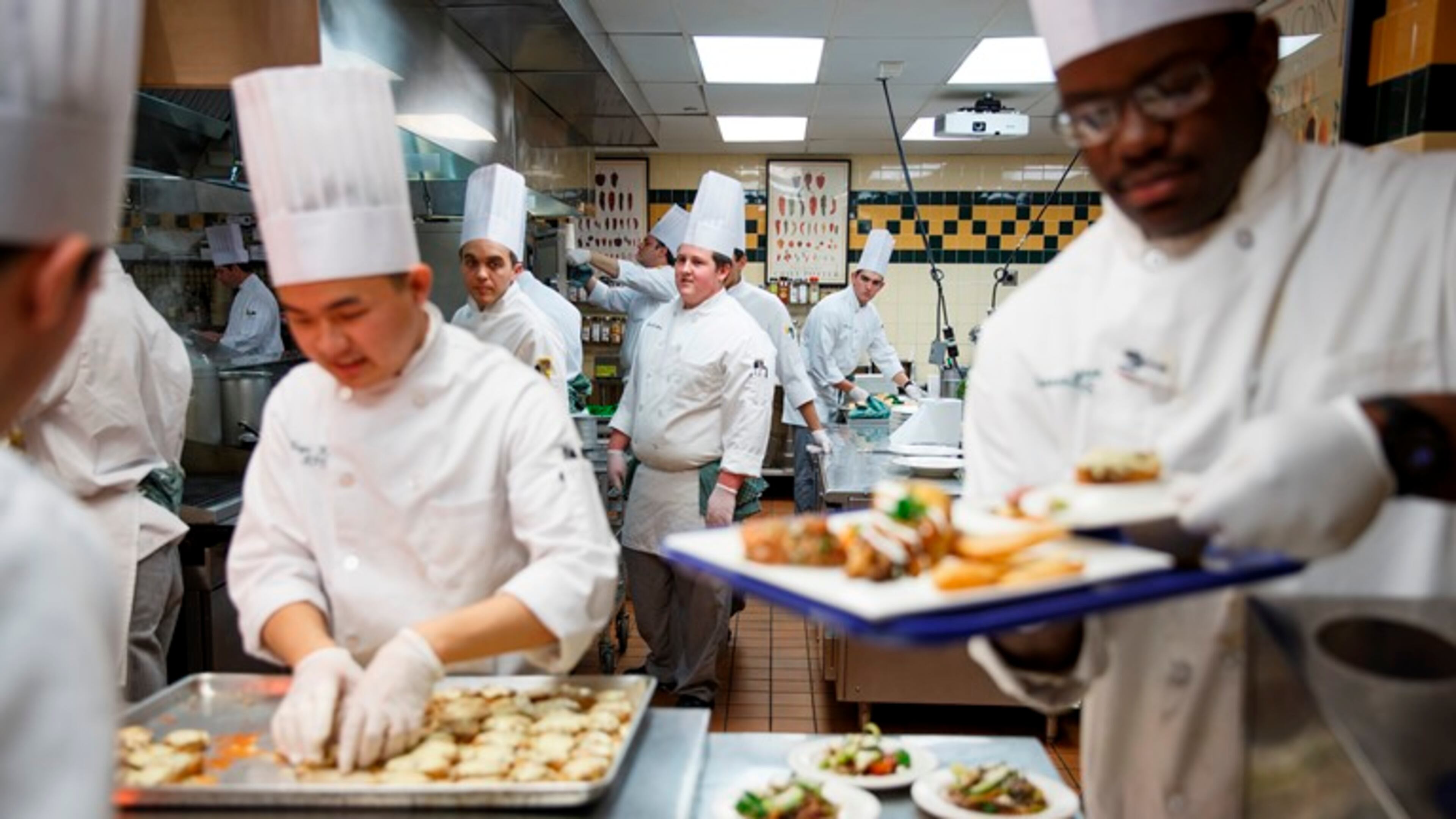 Nico Christiansen, background right, in class at the Culinary Institute of America in Hyde Park, N.Y., Nov. 16, 2015. Christiansen also plays for the Steels, the CIA’s basketball team — a commitment that requires careful time management given the 6 1/2 hours students spend on their feet in the kitchens daily.