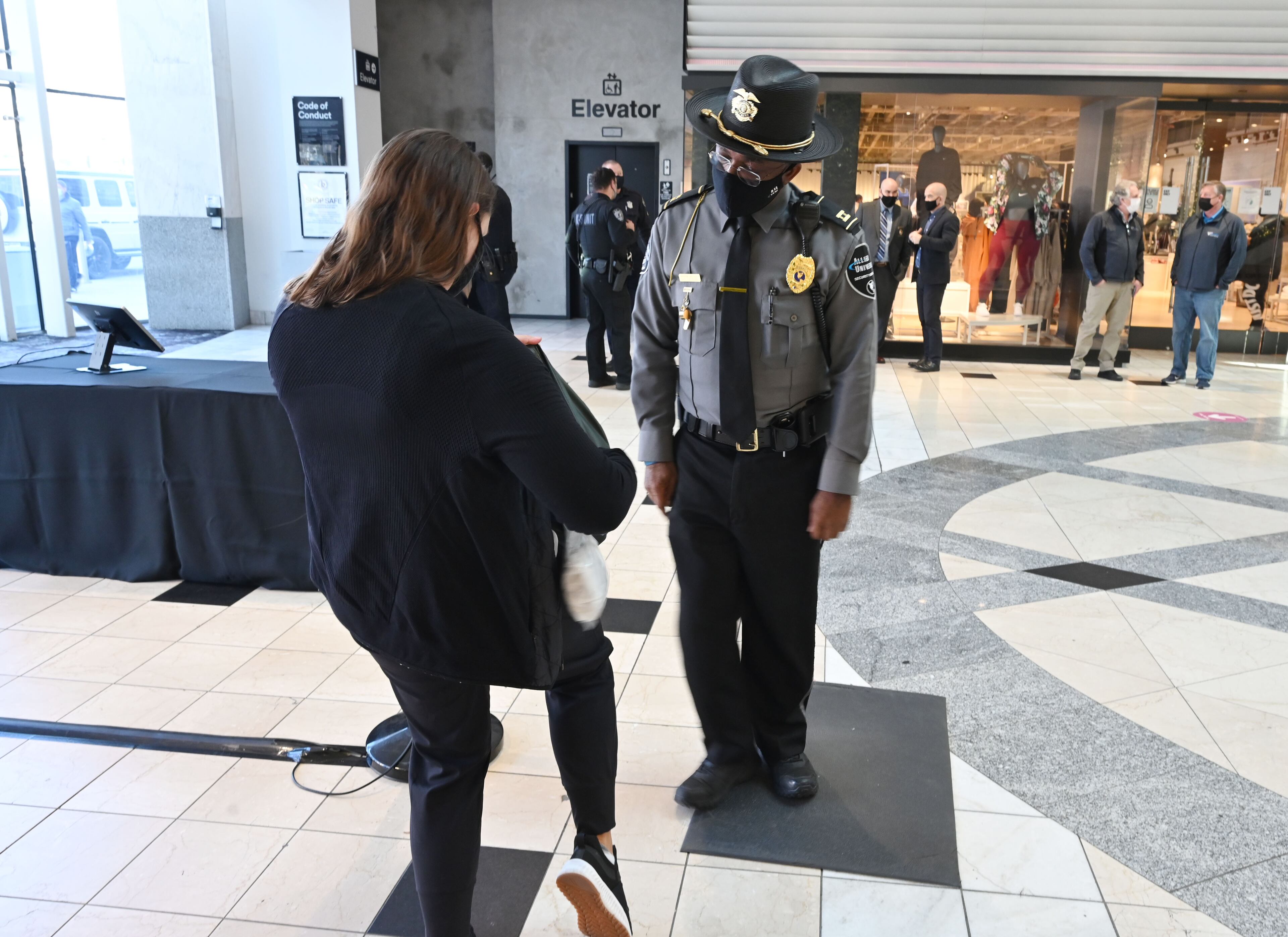 Kenyonn Wallace, security with the mall, inspects a bag after a metal detector alarmed at Lenox Square on December 29, 2020. Lenox Square, in the heart of Buckhead, was the site of numerous shooting incidents that year. The Atlanta Police Department has a mini-precinct inside the mall, which has increased security in recent months. (Hyosub Shin / Hyosub.Shin@ajc.com)
