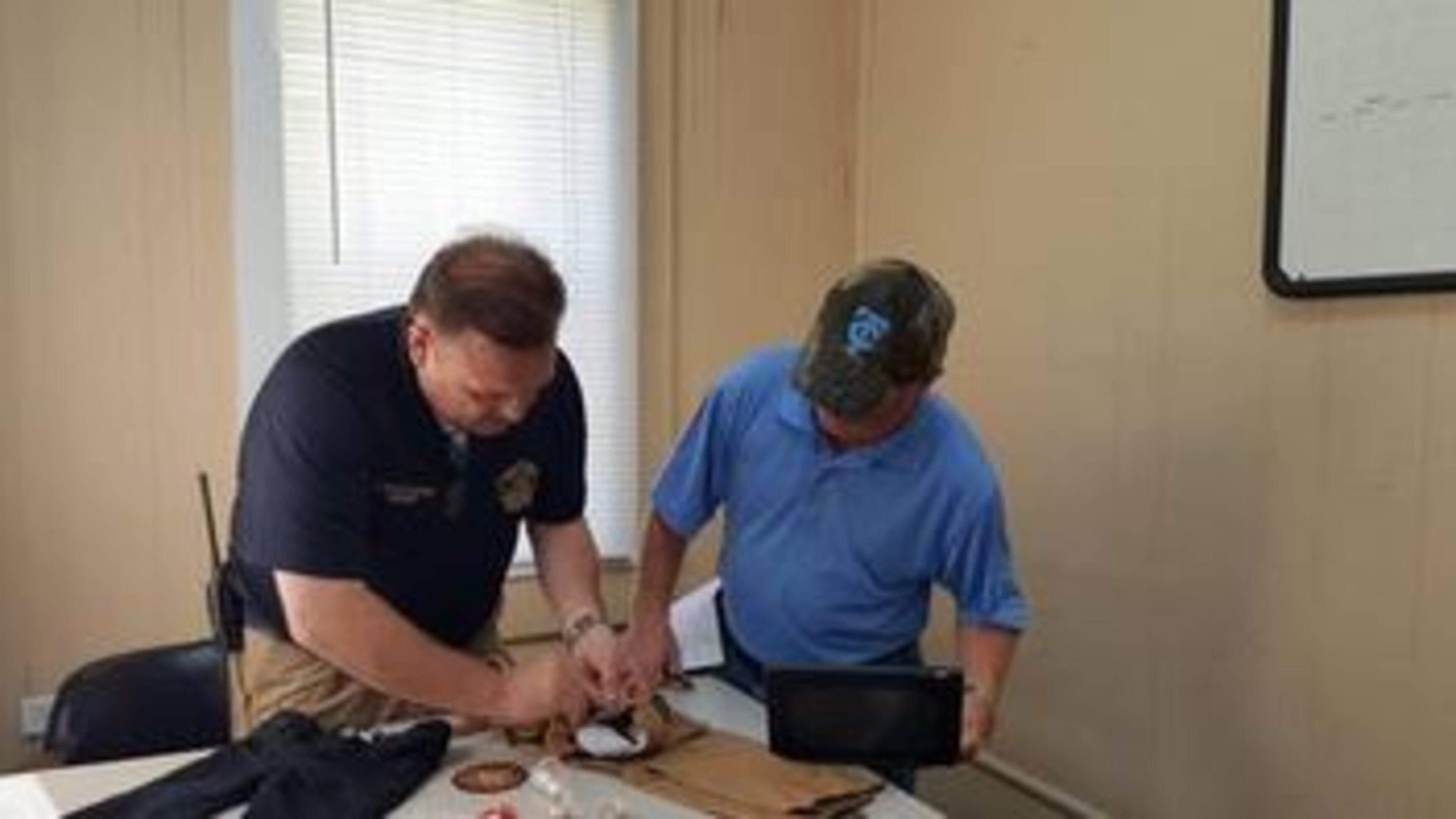 Telfair County Sheriff Chris Steverson (left) and Telfair State Prison Warden Phil Hall remove suspected marijuana from childrens’ pants. (Credit: Macon Telegraph)