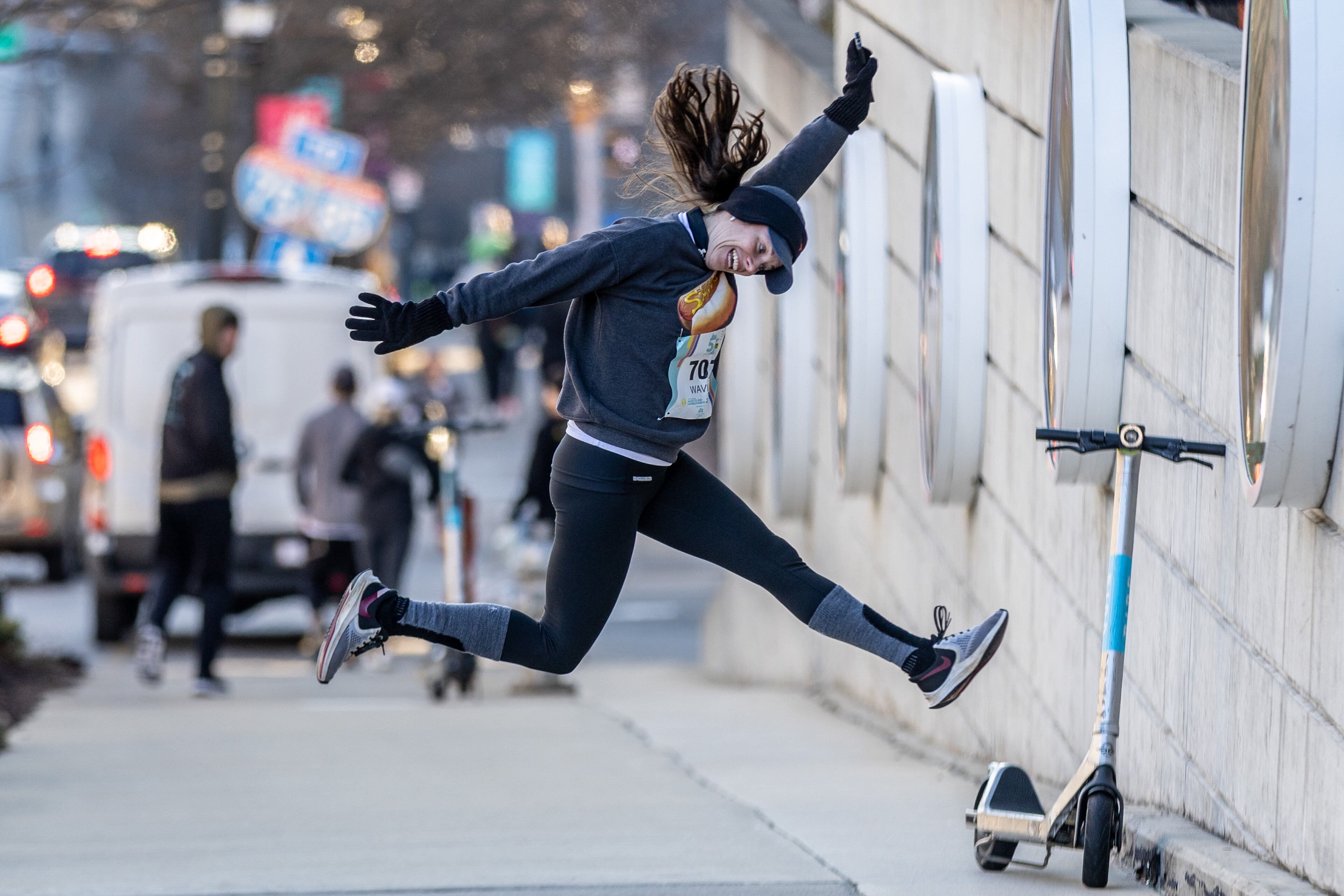 Katie Sanders jumps in the air when she sees her friends as they head to the starting line of the 20th Annual Atlanta Mission 5K Race to End Homelessness in Atlanta Saturday morning, Feb. 18, 2023. (Steve Schaefer/steve.schaefer@ajc.com)