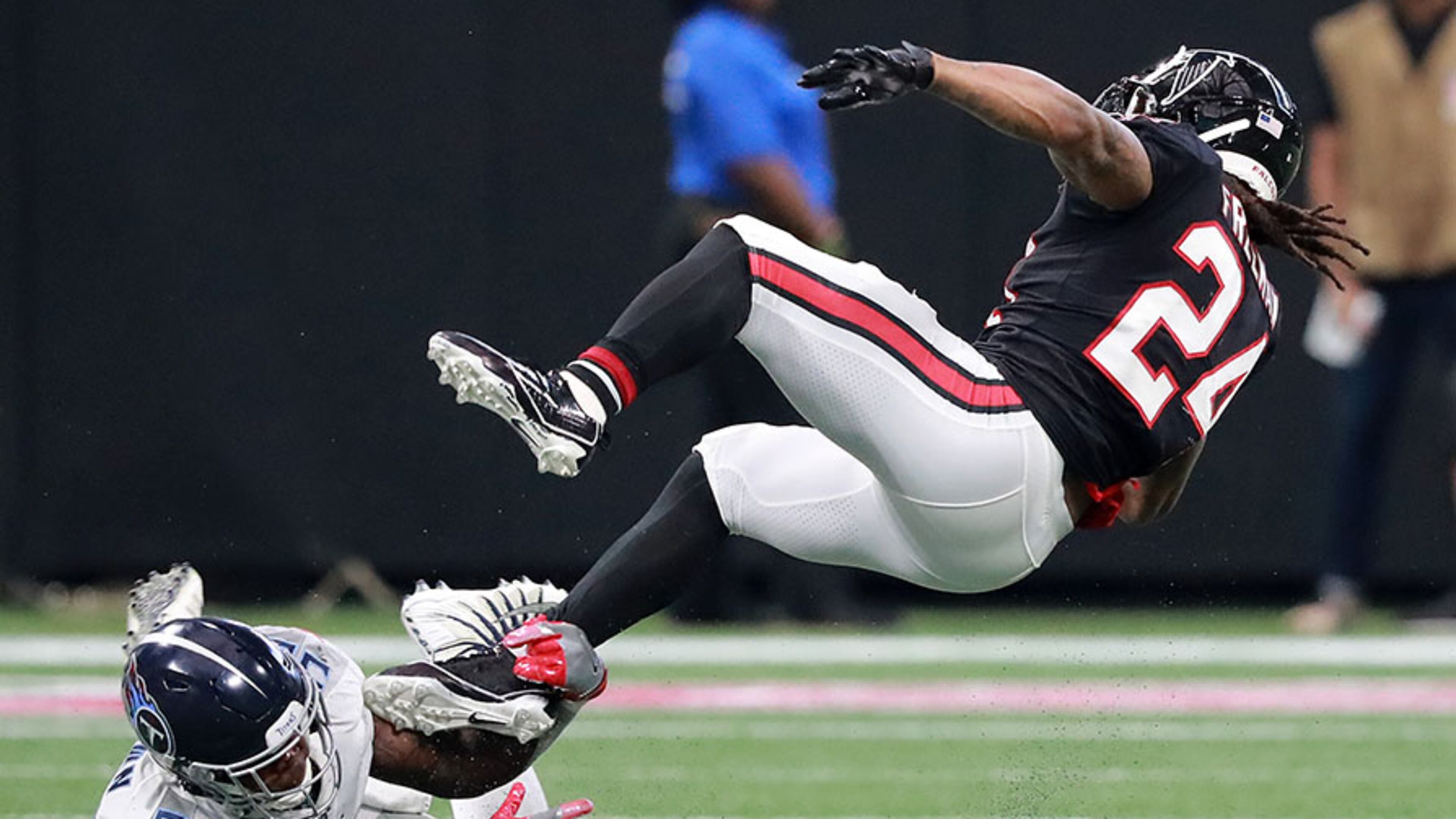 Falcons running back Devonta Freeman is upended by Titans linebacker Jayon Brown Sunday, Sept. 29, 2019, at Mercedes-Benz Stadium in Atlanta.