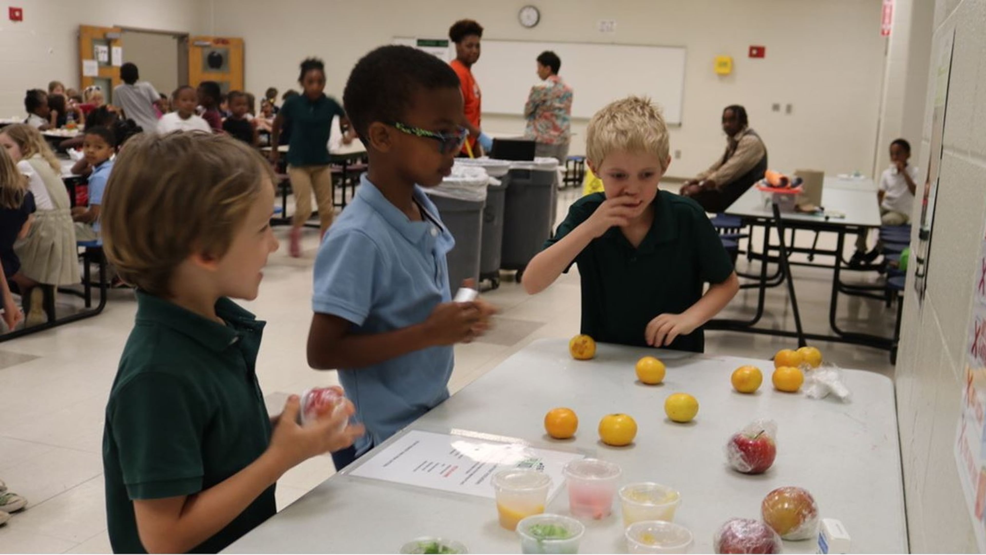 Students Hudson Pensinger, Prana Heab Williams and Nathan Colvin have their choice of food items on the share table at Parkside Elementary School. CONTRIBUTED