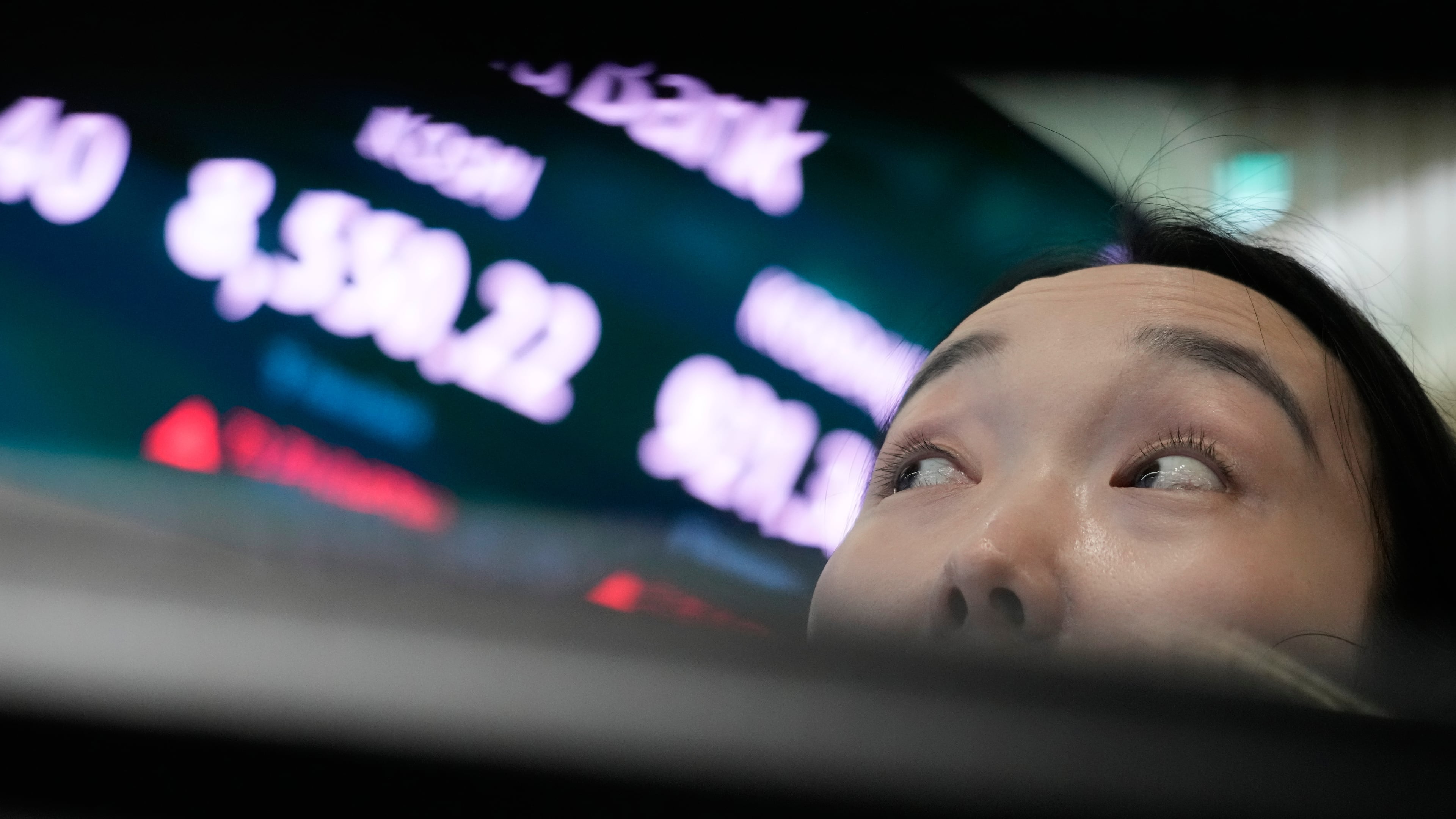 A currency trader watches monitors near a screen showing the Korea Composite Stock Price Index (KOSPI) at the foreign exchange dealing room of the Hana Bank headquarters in Seoul, South Korea, Wednesday, July 1, 2026. (AP Photo/Ahn Young-joon)