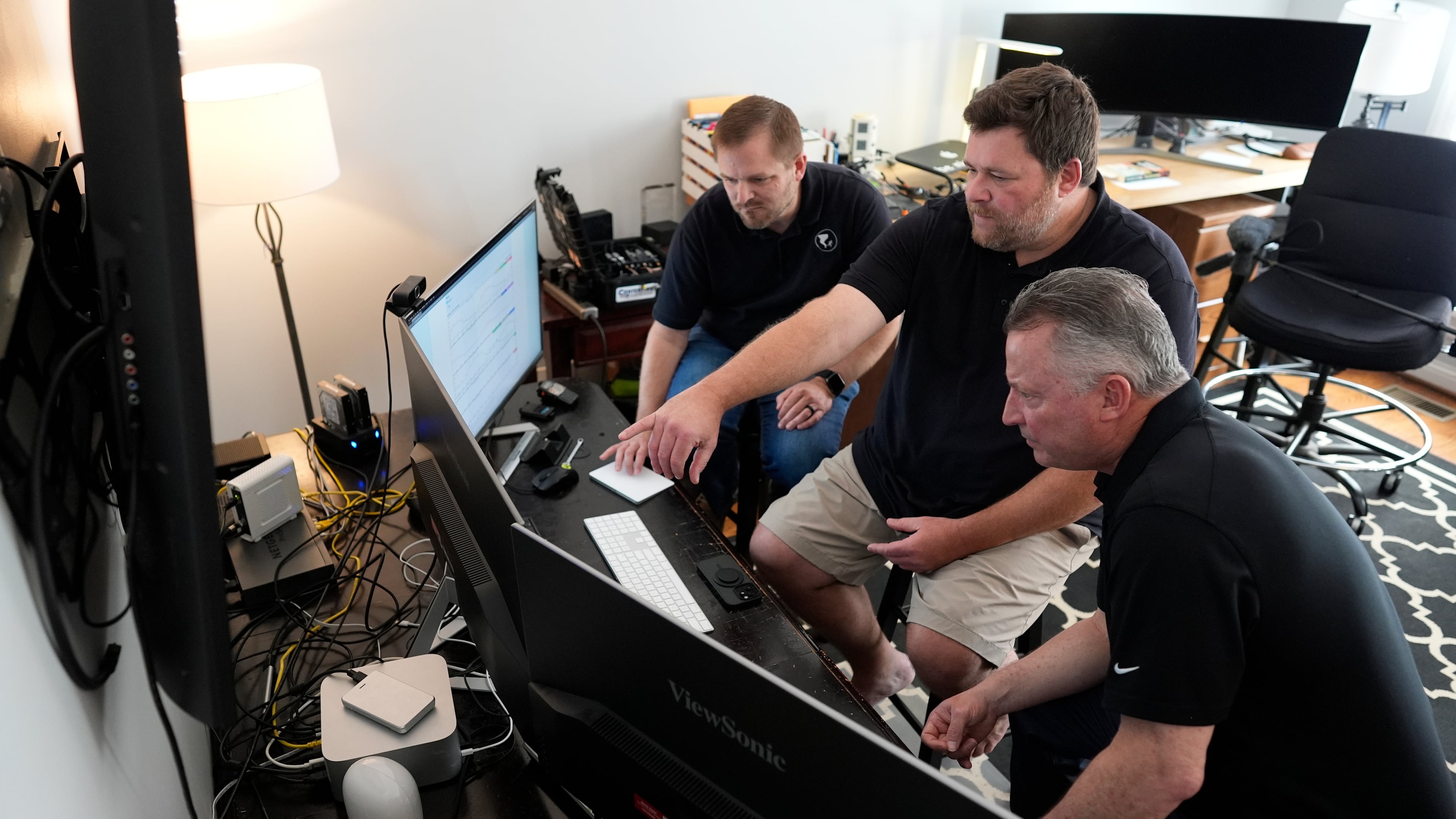 Andrew Leeper, left, Will Minkoff and Tom Johnstone, right, of Nashville Severe Weather, look over weather data Monday, April 20, 2026, in Nashville, Tenn. (AP Photo/George Walker IV)