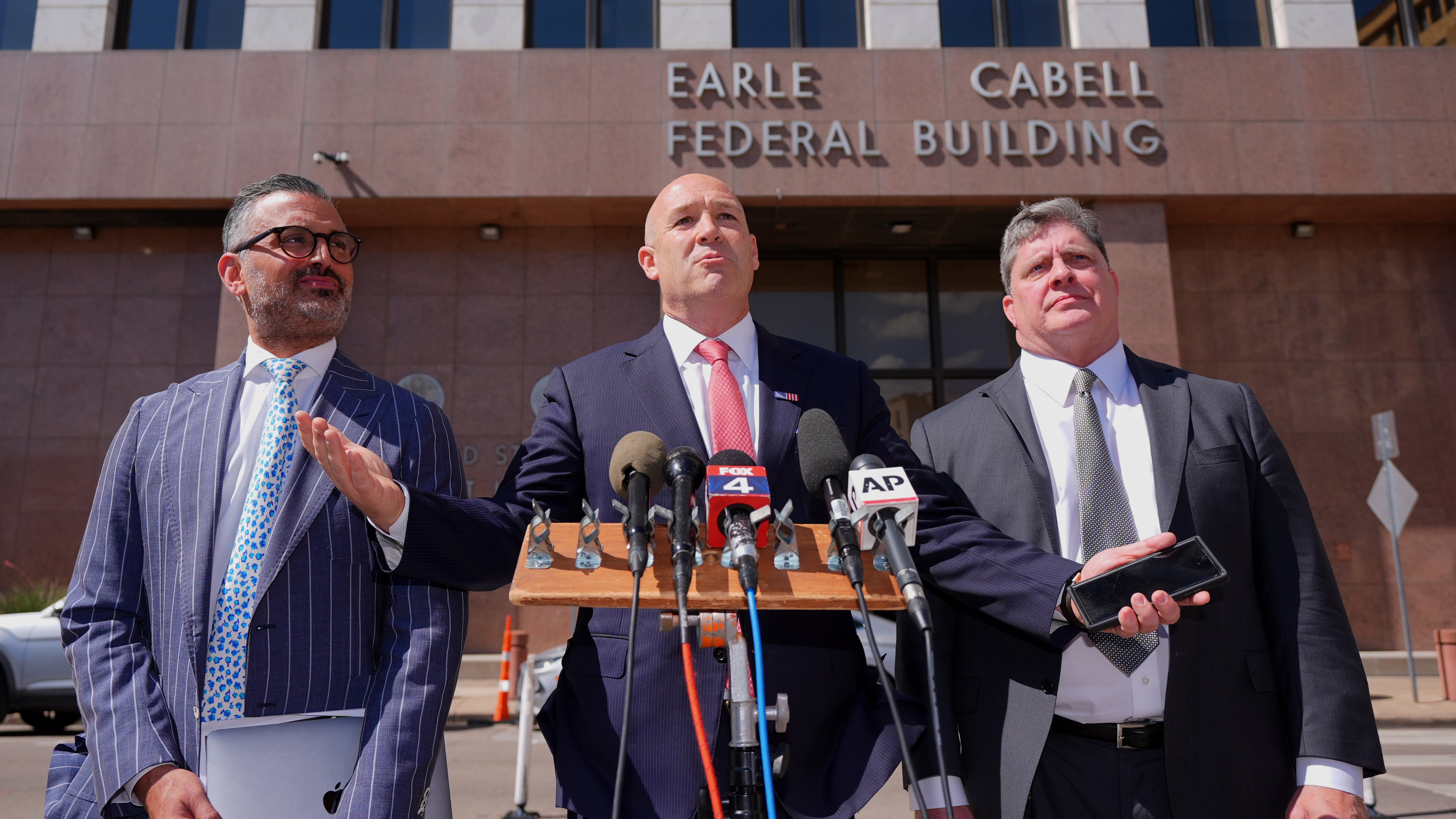 Attorney Bradford Cohen, center, speaks with fellow lawyers Saam Zangeneh, left, and John Helms after a detention hearing in Federal Court for their client rapper Pooh Shiesty, whose legal name is Lontrell Williams Jr., in Dallas, Wednesday, April 8, 2026. (AP Photo/LM Otero)