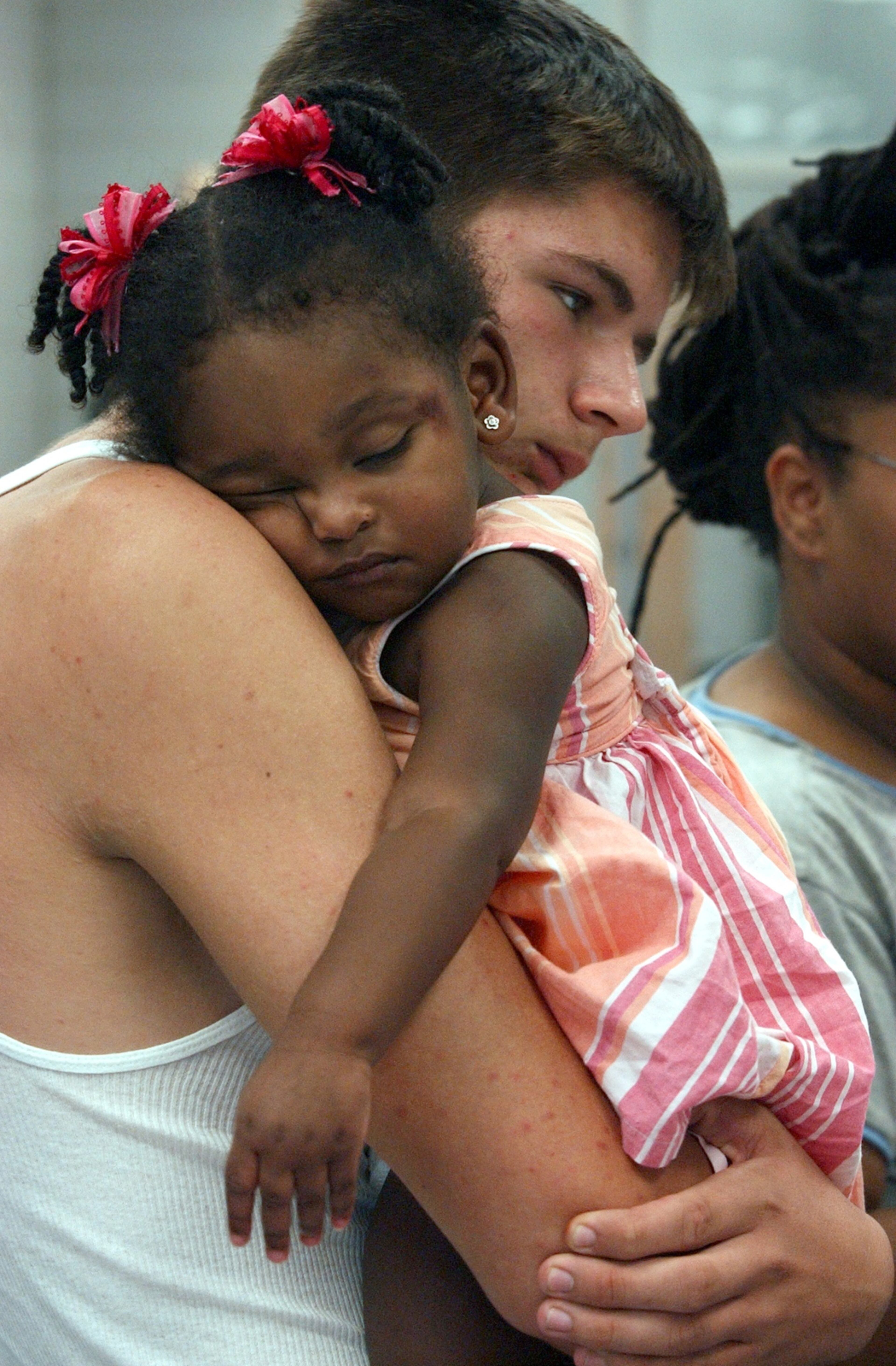 050831 ATLANTA, GA: Refugees from New Orleans converge on the Adamsville YMCA where the City of Atlanta and the Red Cross has set up a refugee center for those who fled Hurricane Katrina. Brett Waguespack (cq) holds his two year old foster neice Endiah Guyton as he stands in line to register for aid. (W.A. BRIDGES JR./Staff).