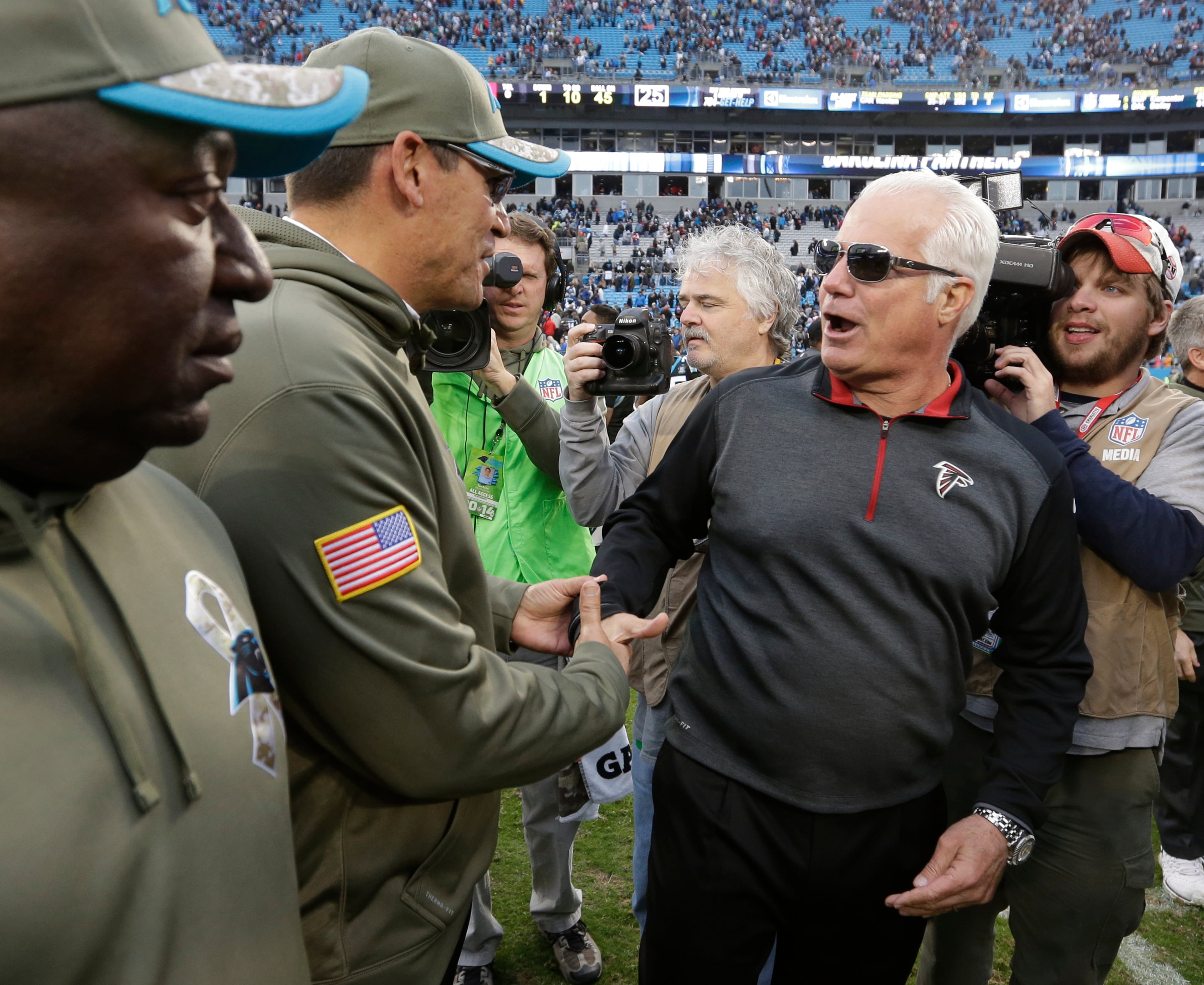 Carolina Panthers head coach Ron Rivera, left, shakes hands with Atlanta Falcons head coach Mike Smith, after an NFL football game in Charlotte, N.C., Sunday, Nov. 16, 2014. The Falcons won 19-17. (AP Photo/Bob Leverone)
