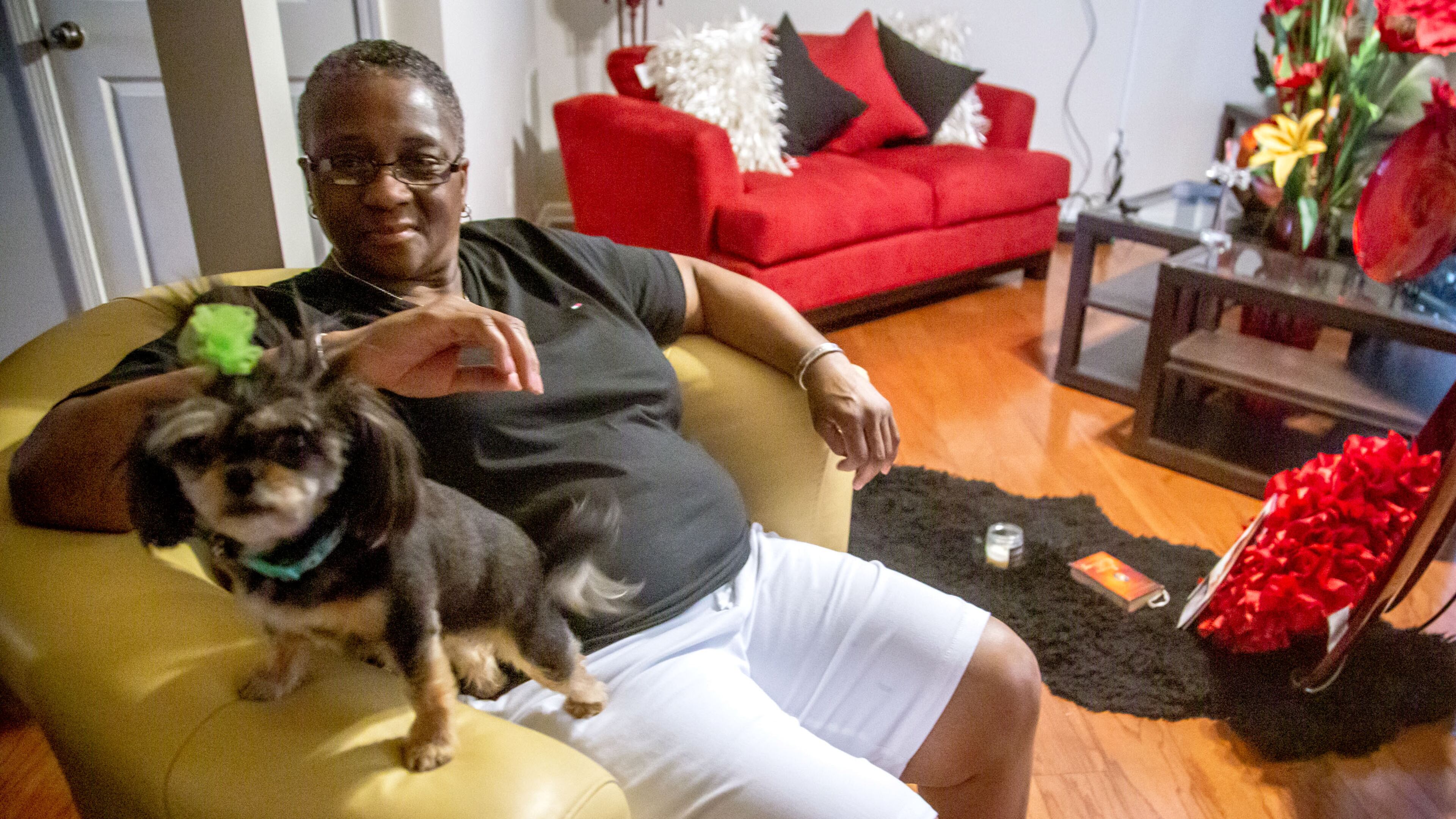 Marcia Body sits in her Jonesboro home with her dog Dora. Body, a cancer survivor, said she had to improvise a face mask when COVID-19 hit the Clayton County Jail. (STEVE SCHAEFER FOR THE ATLANTA JOURNAL-CONSTITUTION)