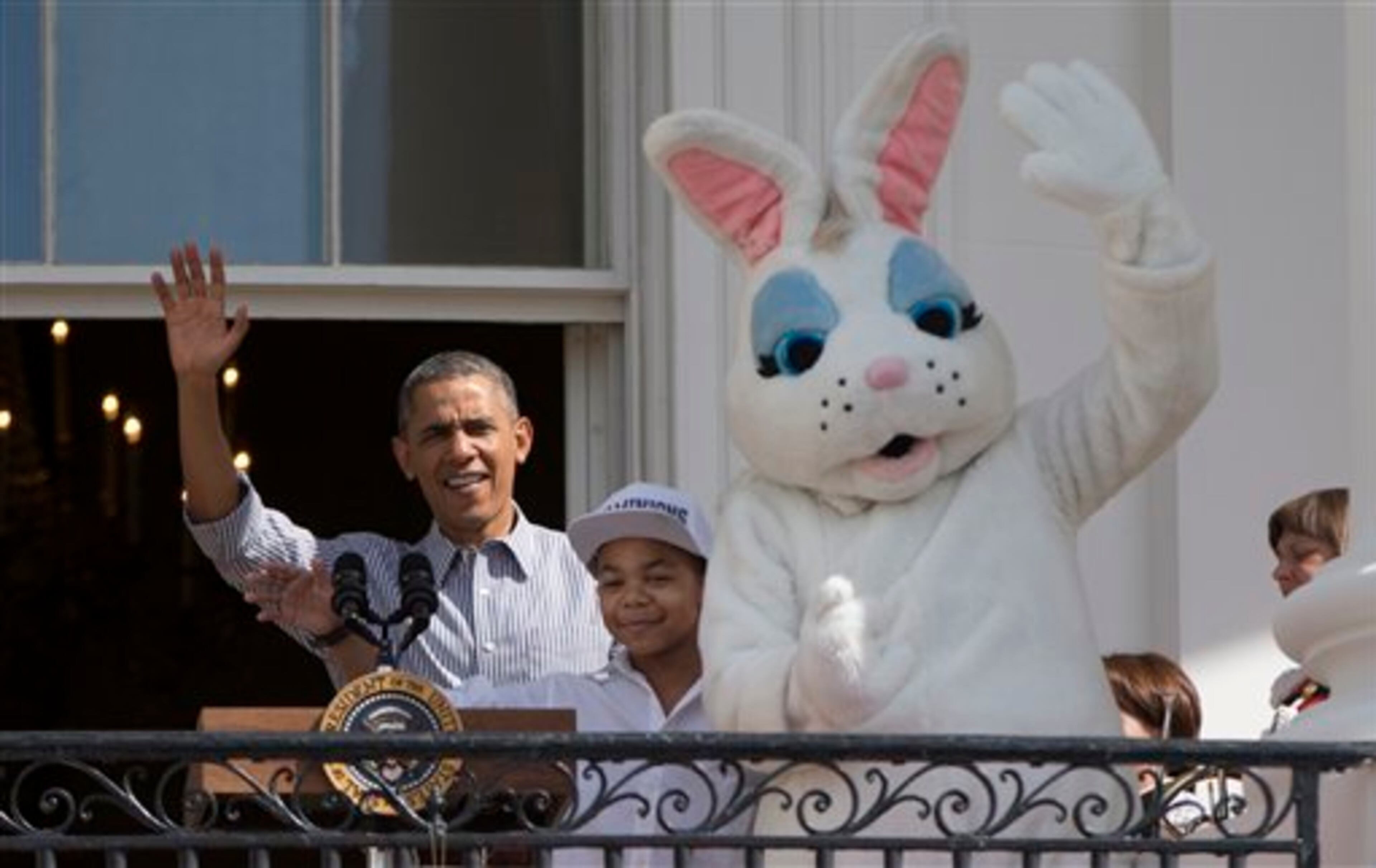 President Barack Obama, singer Cam Anthony, and the Easter Bunny wave from the Truman Balcony of the White House in Washington, Monday, April 21, 2014, during the White House Easter Egg Roll on the South Lawn. Thousands of children are gathered at the White House for the annual Easter Egg Roll. This year's event features live music, cooking stations, storytelling, and of course, some Easter egg rolling. (AP Photo/Carolyn Kaster)
