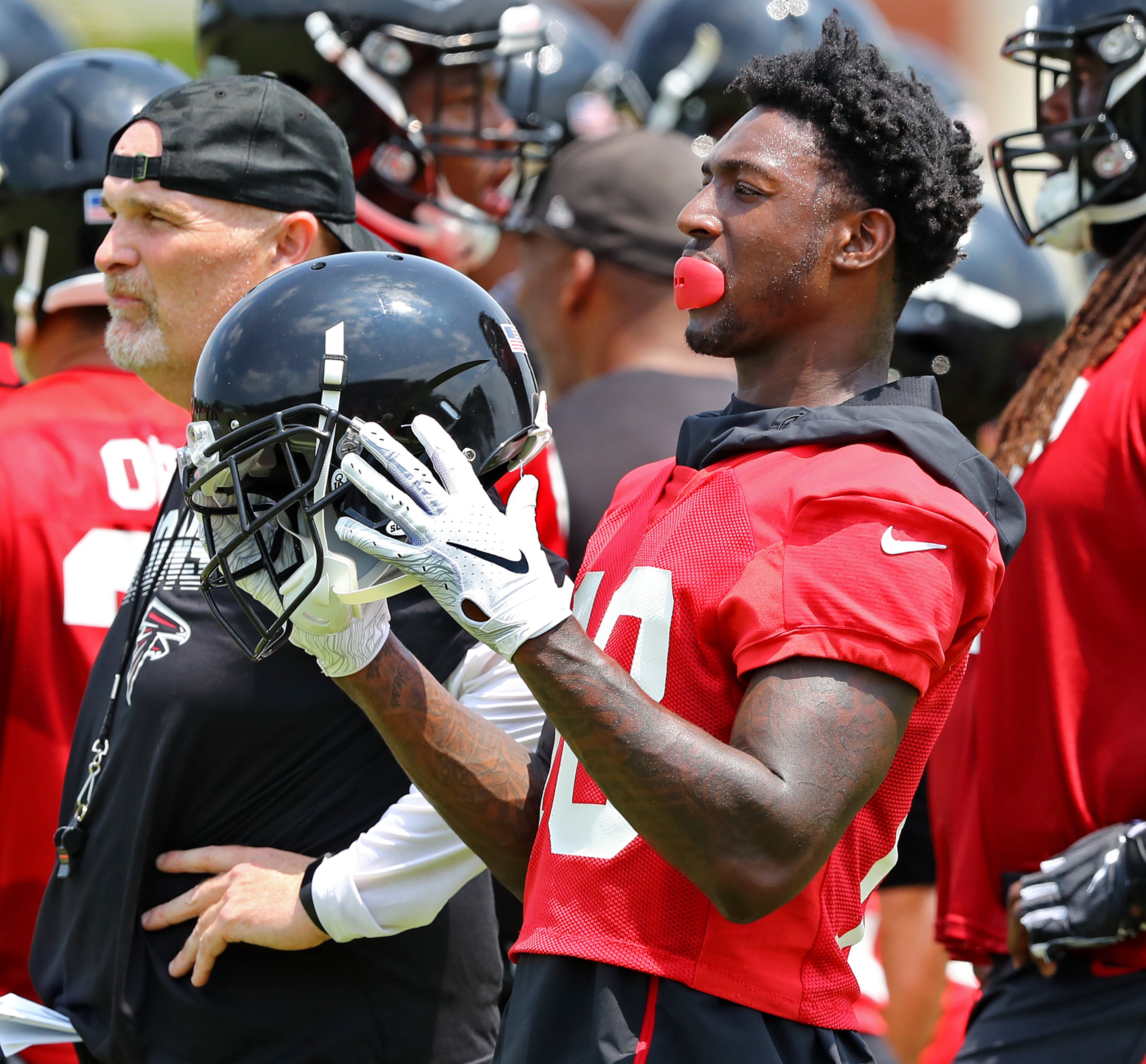 Falcons wide receiver Calvin Ridley prepares to run a play after confering with head coach Dan Quinn. Curtis Compton/ccompton@ajc.com