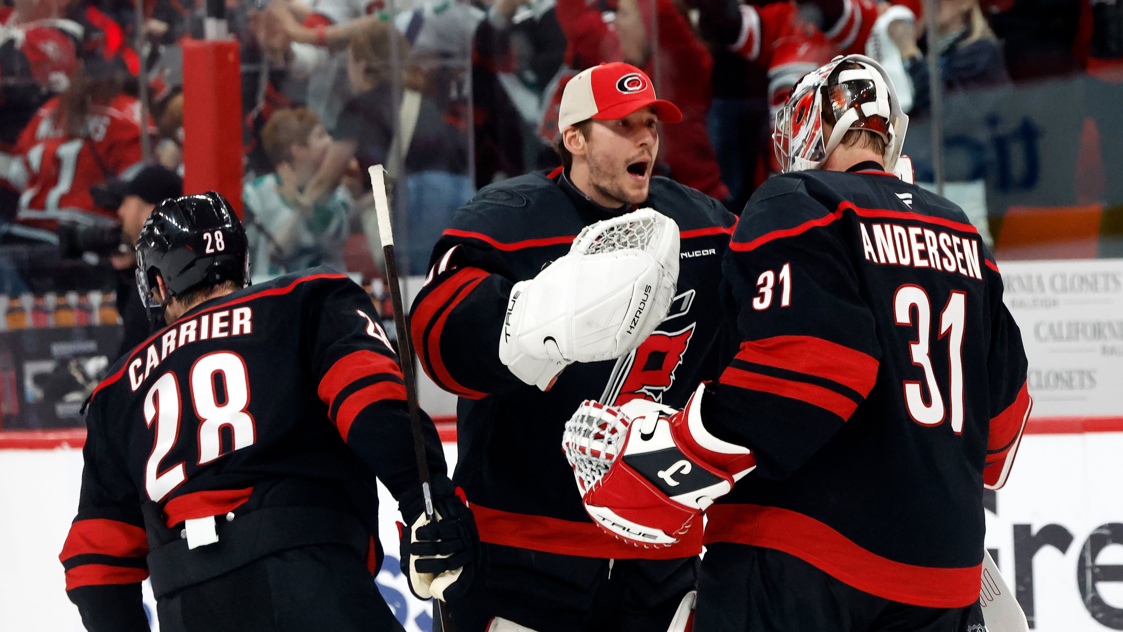 Carolina Hurricanes goaltender Brandon Bussi (32) congratulates goaltender Frederik Andersen (31) with William Carrier (28), following the second overtime of Game 2 of an NHL hockey Stanley Cup first-round playoff series against the Ottawa Senators in Raleigh, N.C., Monday, April 20, 2026. (AP Photo/Karl DeBlaker)
