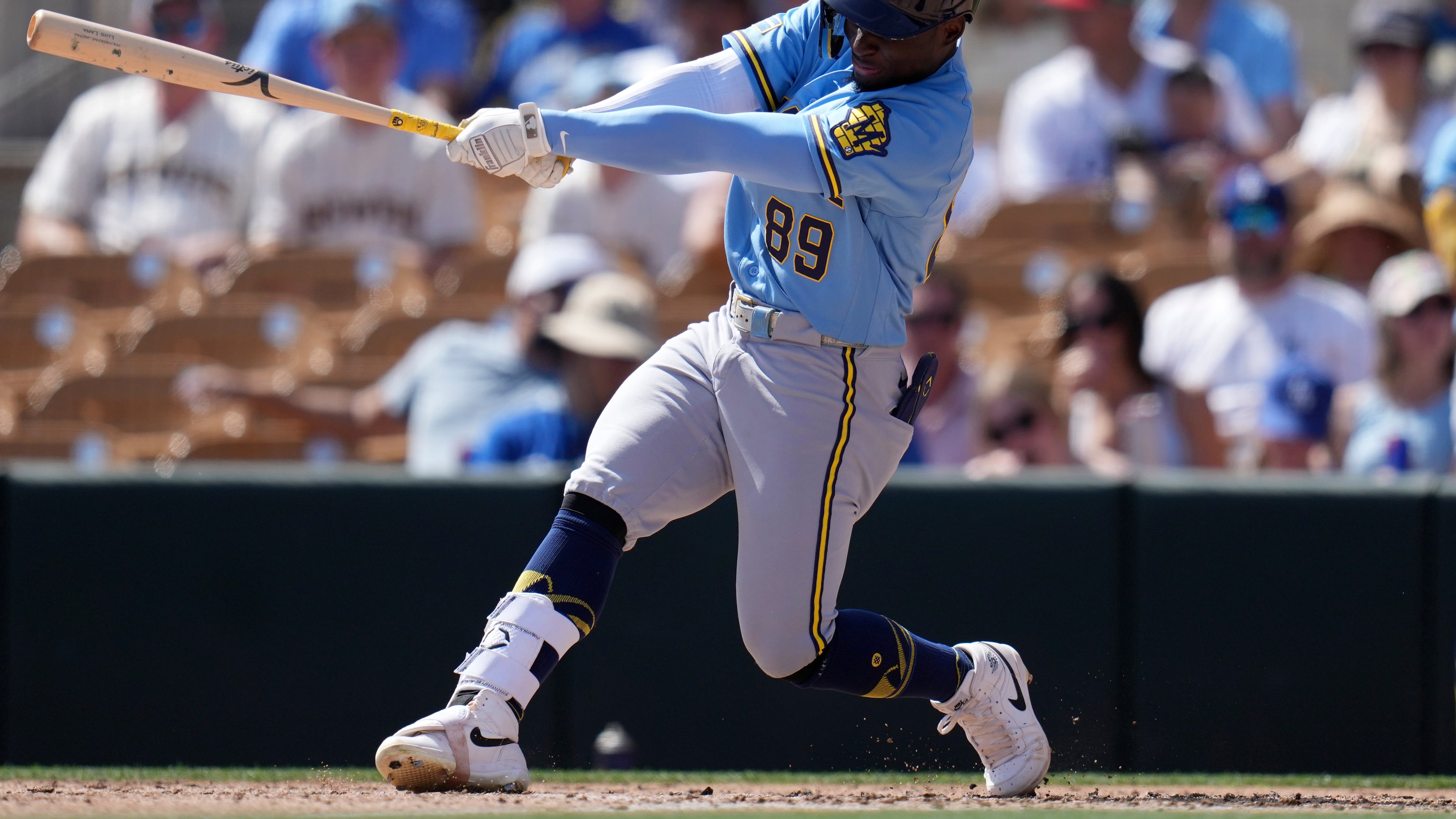 FILE - Milwaukee Brewers' Luis Lara follows through with his swing against the Los Angeles Dodgers during the third inning of a spring training baseball game, Monday, March 16, 2026, in Phoenix. (AP Photo/Ross D. Franklin,File)