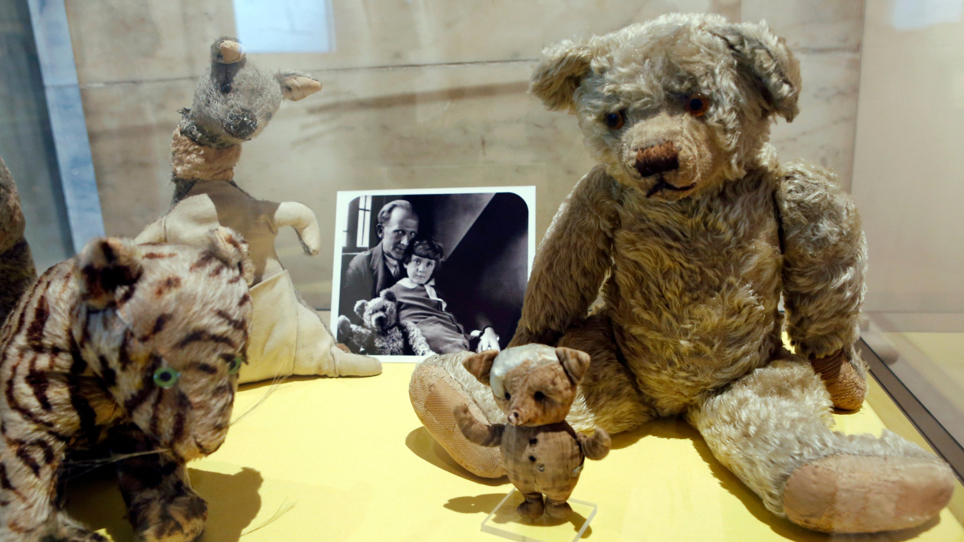 FILE - A photograph of author A. A. Milne with his son Christopher Robin is displayed beside Milne's son Christopher Robin's beloved teddy bear, the inspiration for "Winne-the-Pooh," at the New York Public Library, Monday, Sept. 30, 2013, in New York. (AP Photo/Kathy Willens,File)