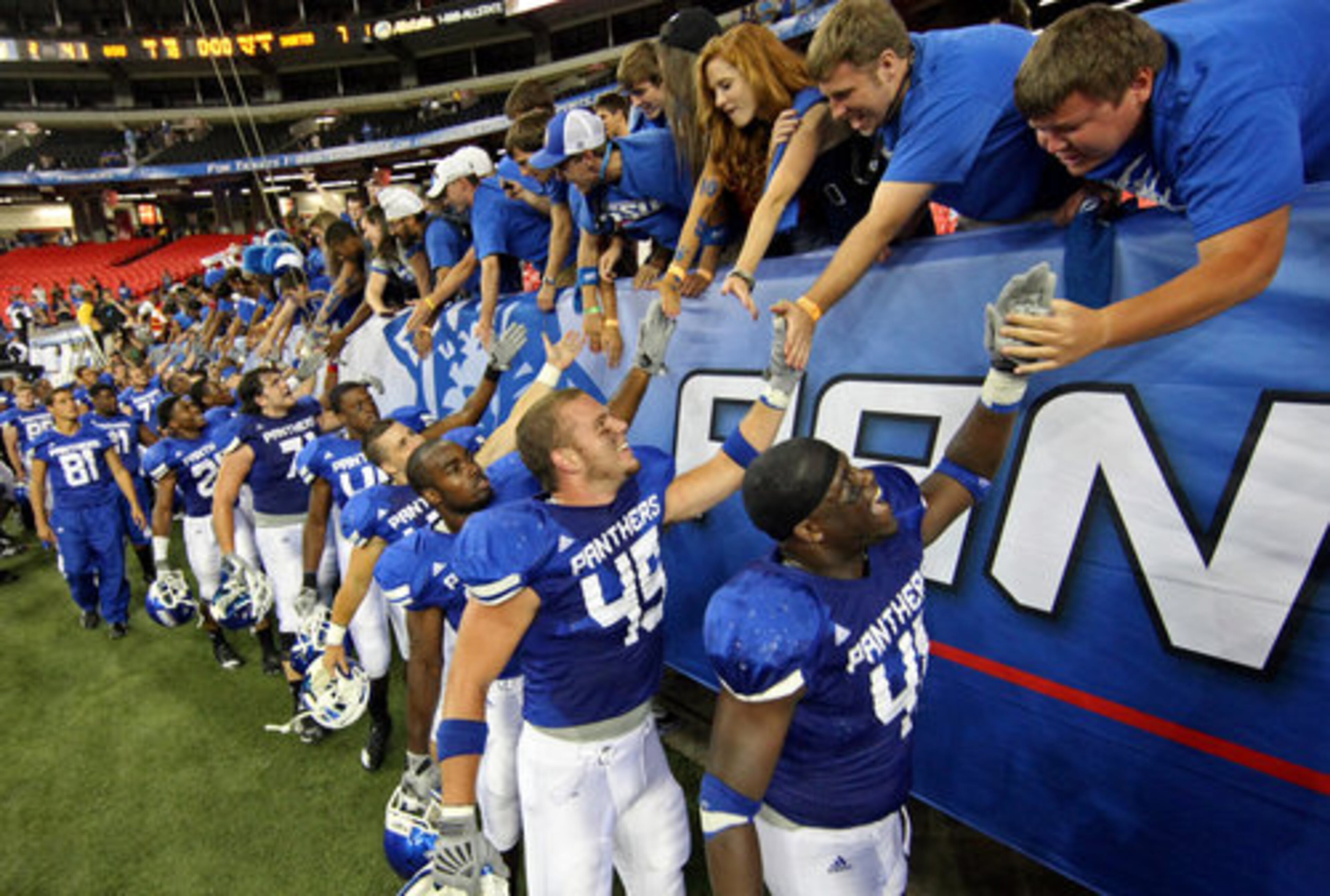 GSU players including Olufemi Opanubi (41, right) and Austen Wiley (45, center) celebrate with fans after their 41-7 win over Shorter College for their first ever win in the Georgia Dome Thursday night in Atlanta, Ga., Sept. 2, 2010.