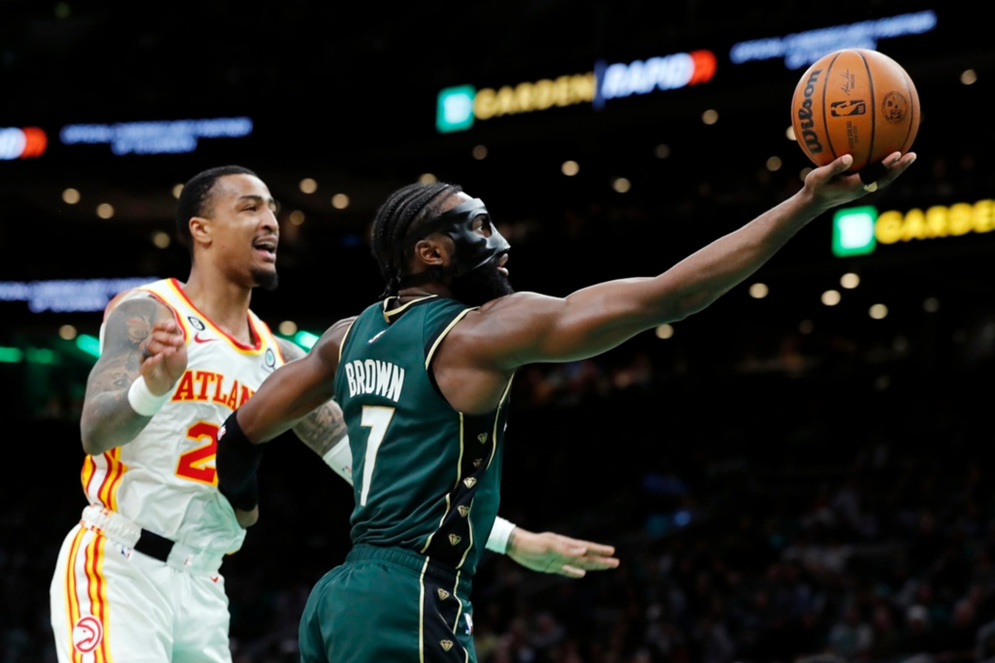 Boston Celtics' Jaylen Brown (7) shoots ahead of Atlanta Hawks' John Collins (20) in the first half during Game 1 in the first round of the NBA basketball playoffs, Saturday, April 15, 2023, in Boston. (AP Photo/Michael Dwyer)