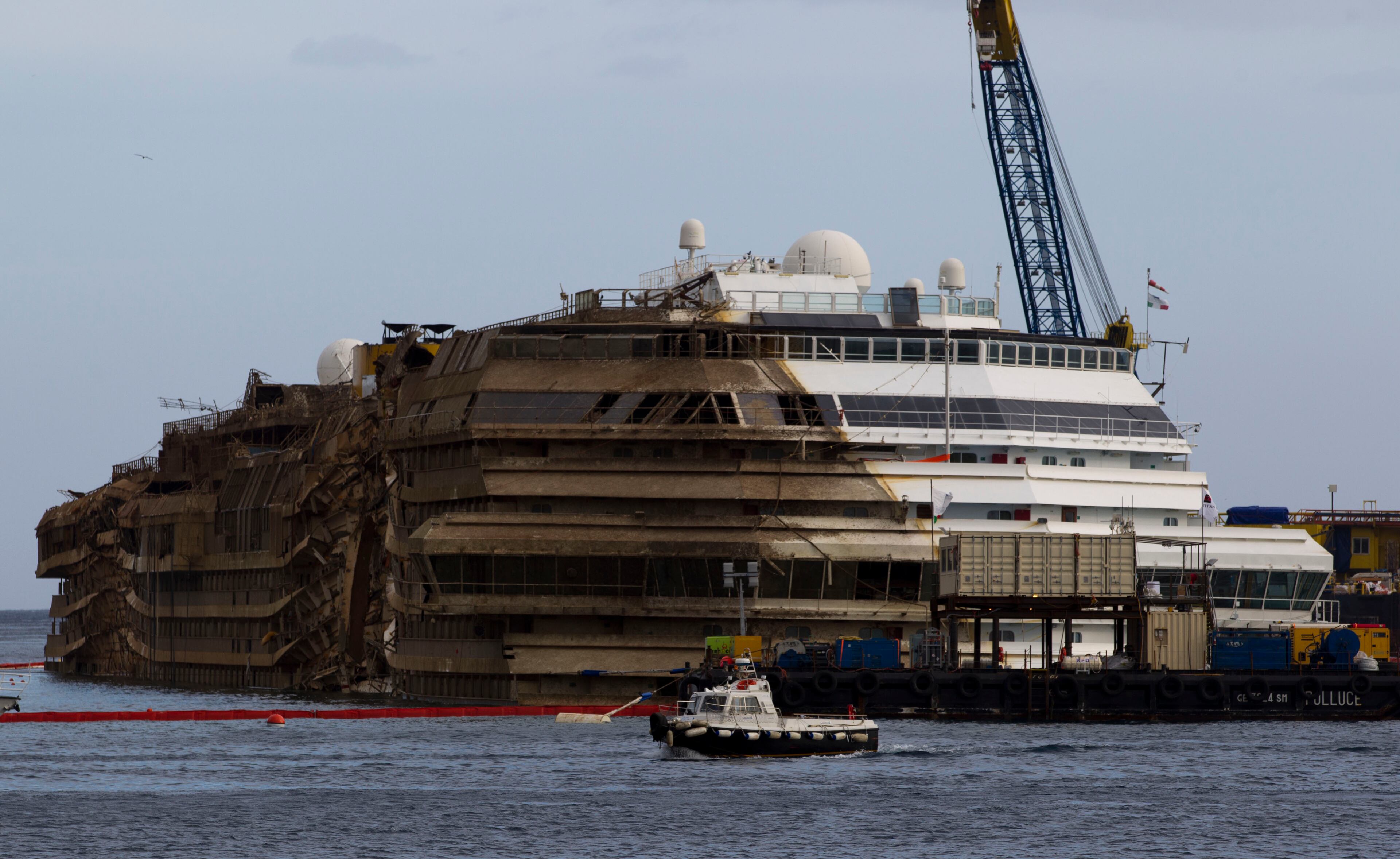 The Costa Concordia is seen after it was lifted upright, on the Tuscan Island of Giglio, Italy, early Tuesday morning, Sept. 17, 2013. The crippled cruise ship was pulled completely upright early Tuesday after a complicated, 19-hour operation to wrench it from its side where it capsized last year off Tuscany, with officials declaring it a "perfect" end to a daring and unprecedented engineering feat. (AP Photo/Andrew Medichini)