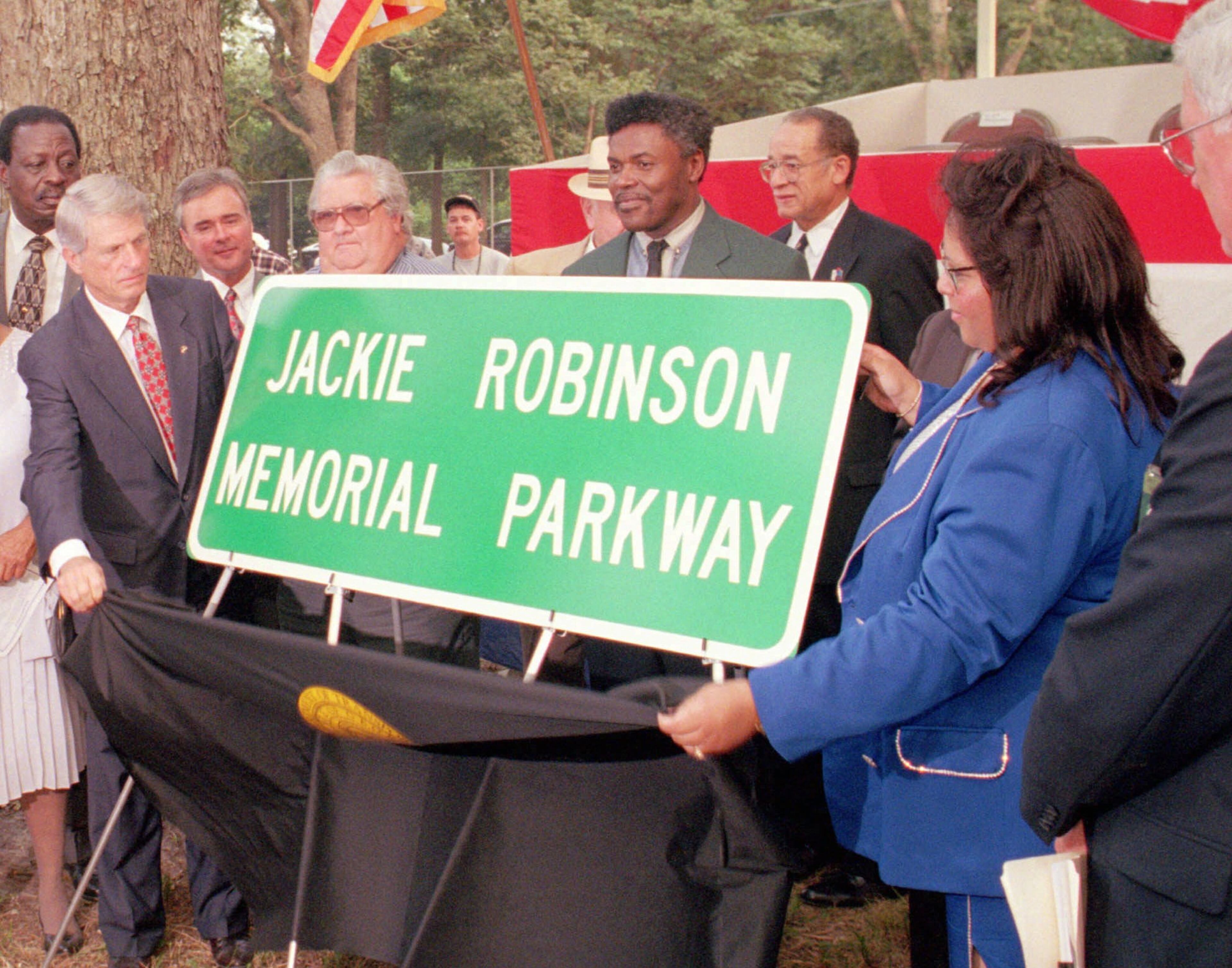 Georgia Governor Zell Miller, left and Linda I. Walden, M.D., president and founder of the Jackie Robinson Cairo Memorial Foundation, right, unveil a sign dedicating a portion of Ga 93 South as the Jackie Robinson Memorial Highway during a ceremony at Cairo High School in Cairo, Ga. Wednesday, Aug. 27, 1997. The baseball legend was born in Cairo. (AP Photo/Thomasville Times Enterprise, Bobby Haven)