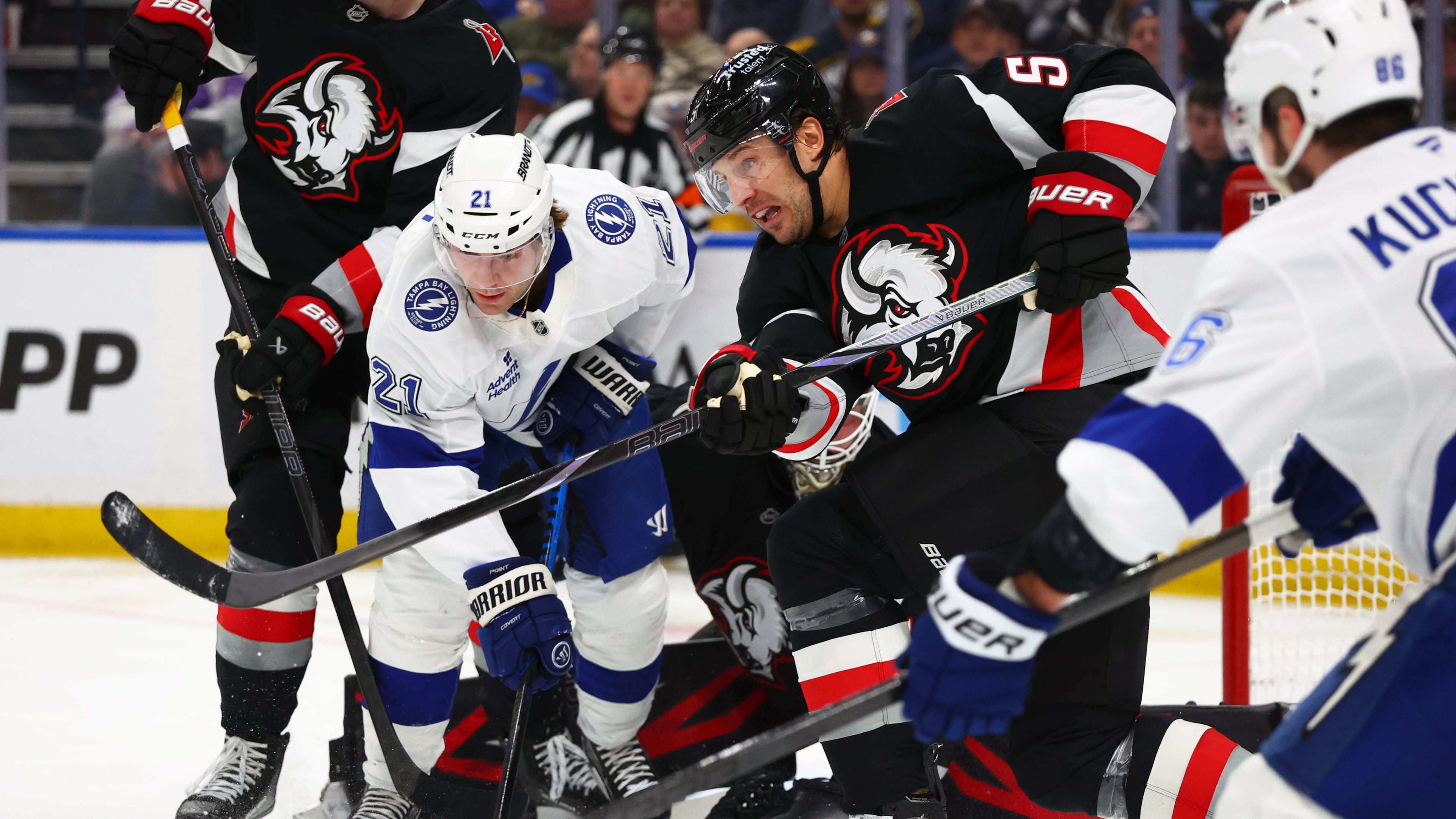 Buffalo Sabres defenseman Luke Schenn (5) clears the puck in front of Tampa Bay Lightning center Brayden Point (21) during the second period of an NHL hockey game Monday, April 6, 2026, in Buffalo, N.Y. (AP Photo/Jeffrey T. Barnes)