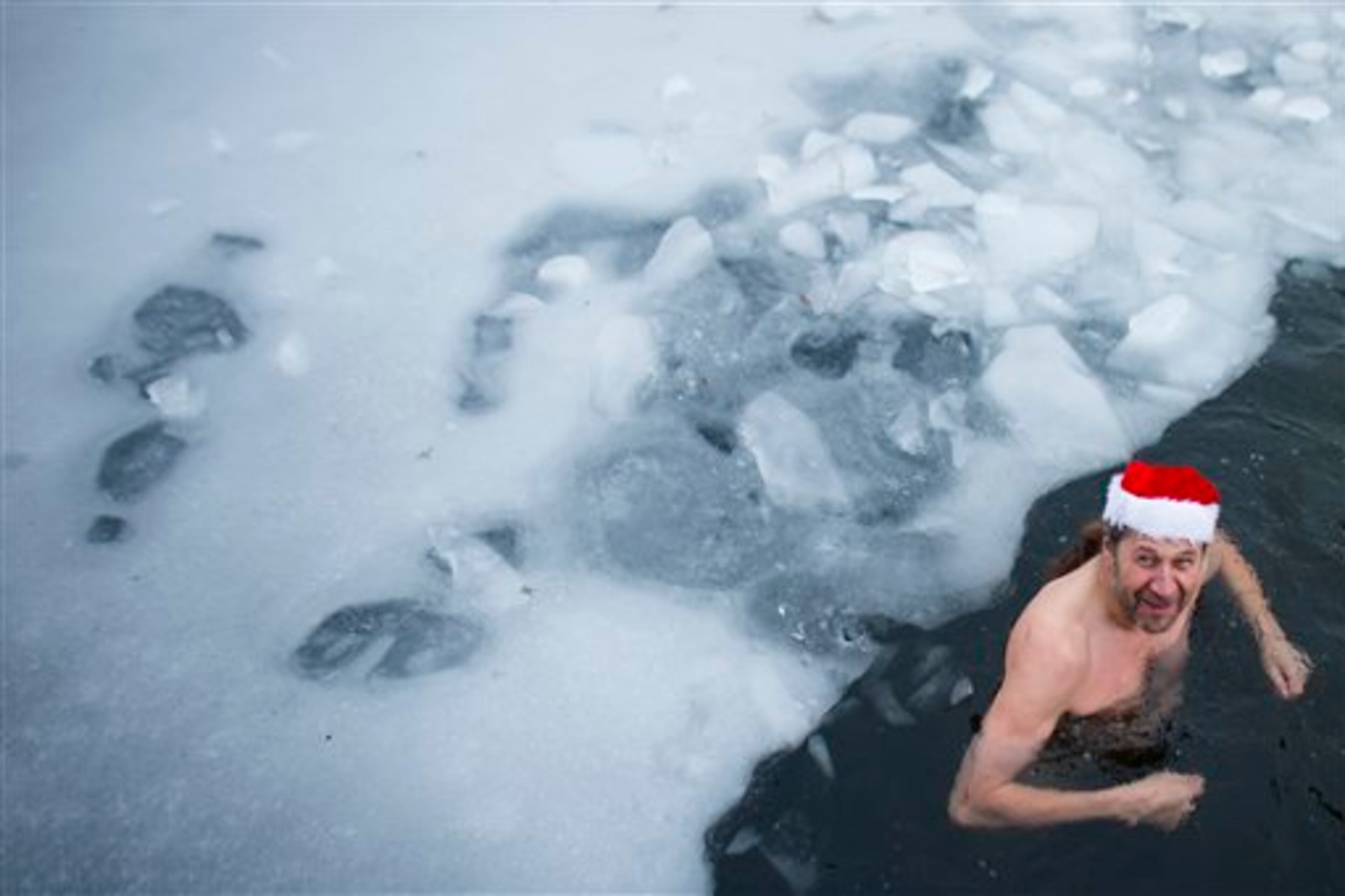 A man in the ice swimming club Berlin Seals attends the annual Christmas swimming at the partial frozen Oranke Lake in Berlin, Tuesday, Dec. 25, 2012. (AP Photo/Markus Schreiber)