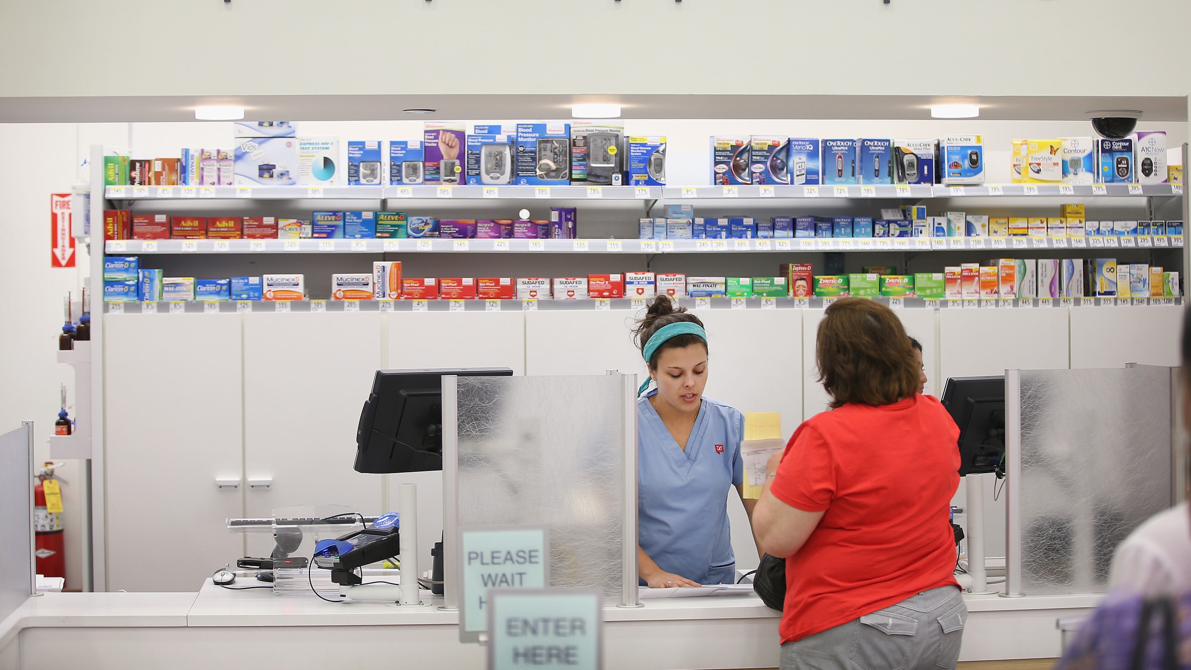 Pharmacy technician Angelina Lombardo helps a customer at a Walgreens pharmacy on September 19, 2013 in Wheeling, Illinois. A December 2016 report says new legislation introduced by Sen. Elizabeth Warren, D-Massachusetts, and Sen. Chuck Grassley, R-Iowa, may allow customers to buy hearing aids over the counter (Photo by Scott Olson/Getty Images)