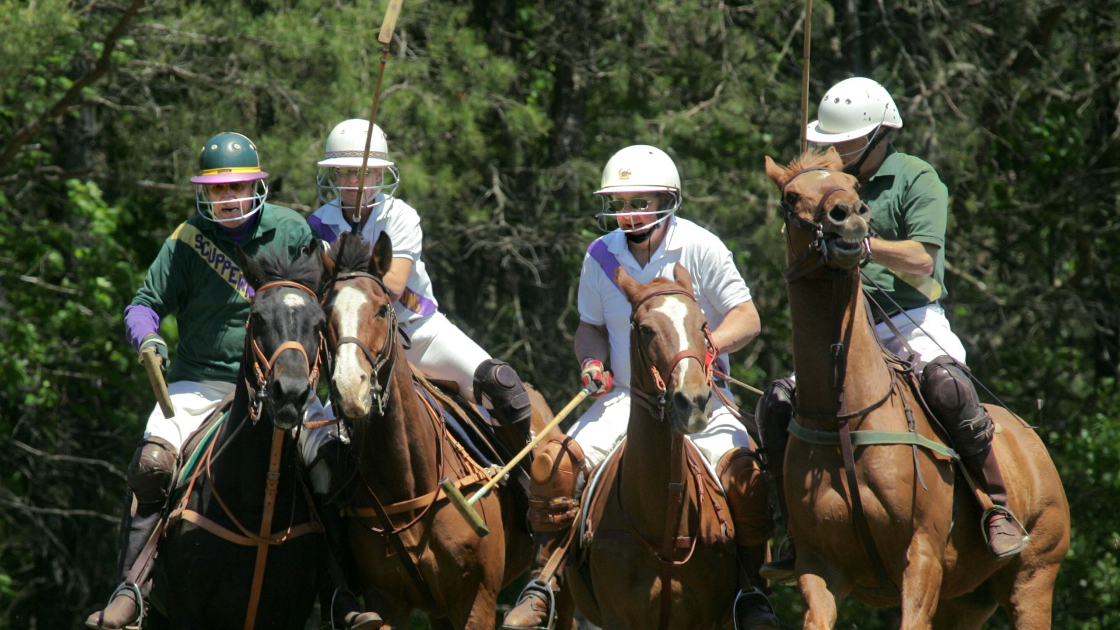 0500501 ALPHARETTA, GA- Jack Cashin, left, Anya Jacobs, second from left, race for the ball during a ride off as Matt Kill, and Matt Cronley, right, keep up during a chukkar in the fourth annual "Sunday in the Country" polo event to benefit MUST Ministries held at Scuppernong Polo Club in Alpharetta, Sunday, May 1, 2005. (Special/John Amis)