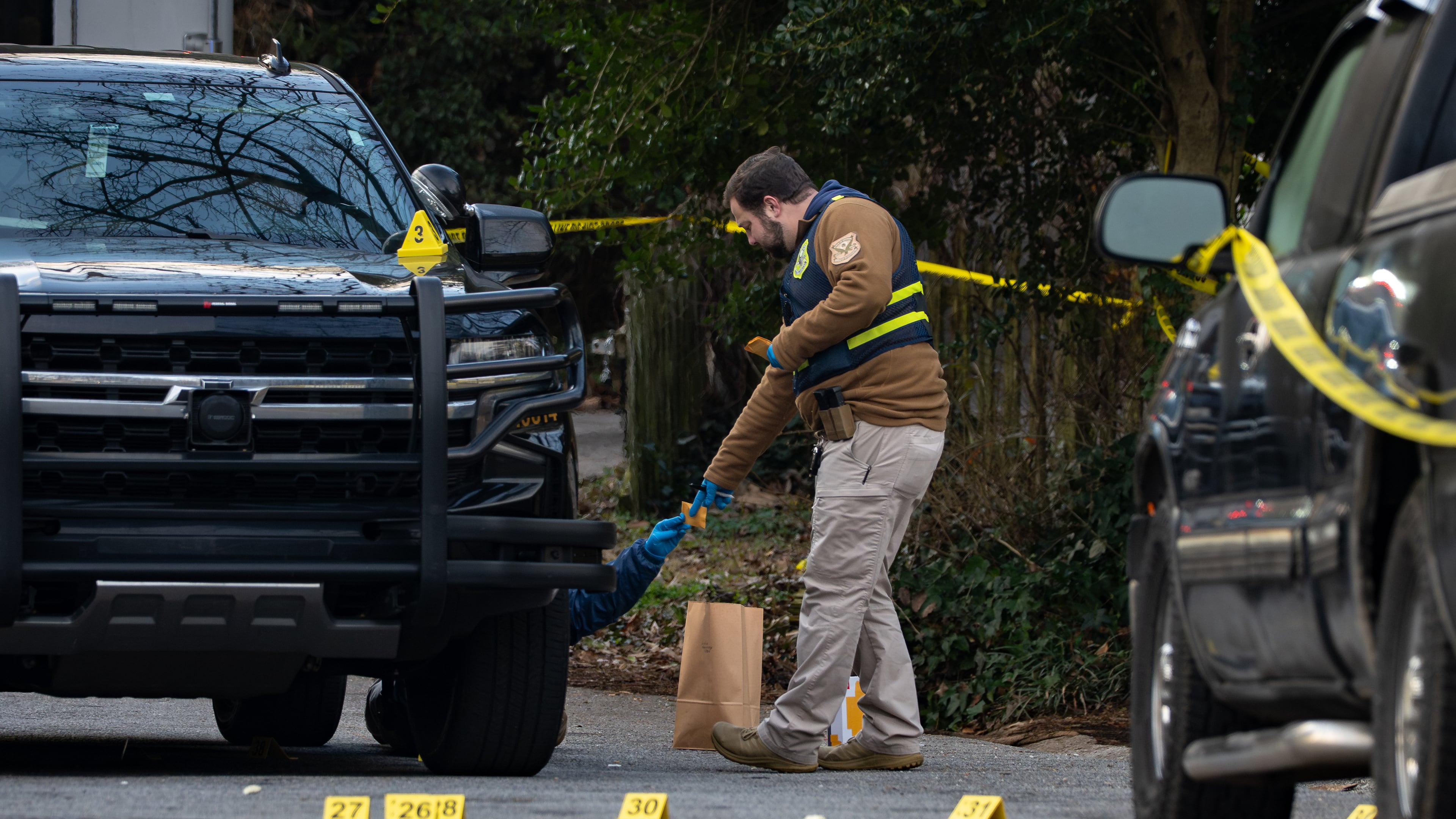 GBI crime scene technicians collect shell casings after a Monday incident in which Cobb County officers shot a man who officials said refused to drop his gun. (Ben Hendren for the AJC)