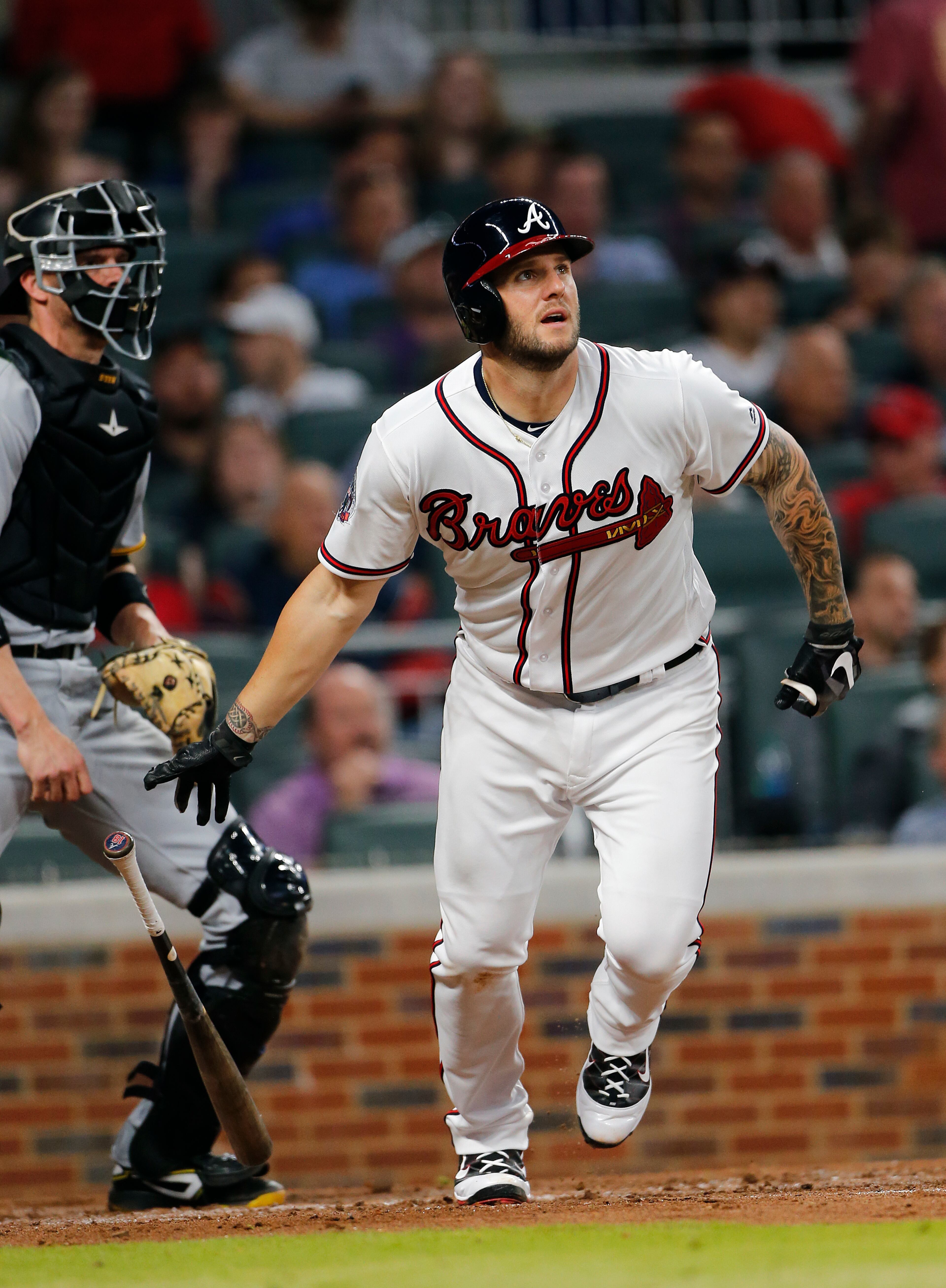 Atlanta Braves' Matt Adams (18) follows through on a triple as Pittsburgh Pirates catcher Chris Stewart (19) looks on in the fourth inning of a baseball game Wednesday, May 24, 2017, in Atlanta. (AP Photo/John Bazemore)