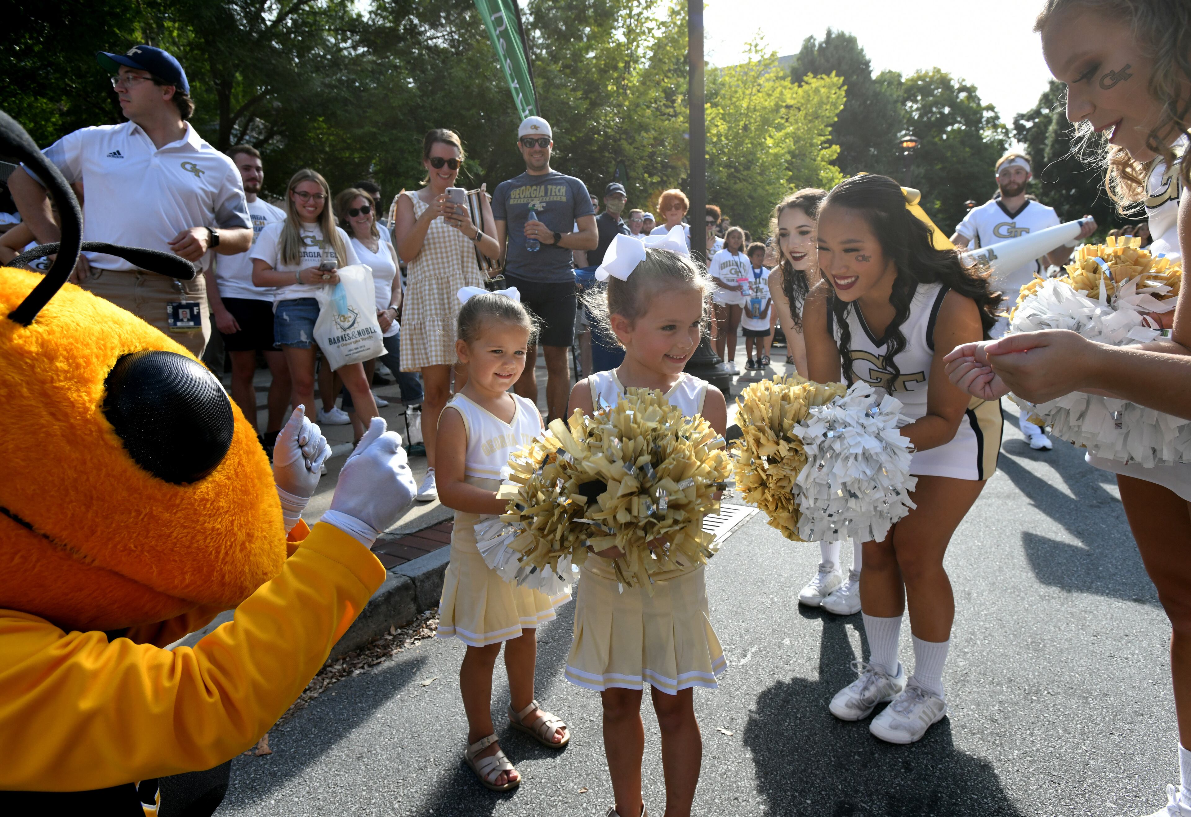 Georgia Tech's mascot, Buzz, and cheerleaders entertain Juliet Amador, 3, (left) and her sister Olivia, 5. (Hyosub Shin / Hyosub.Shin@ajc.com)
