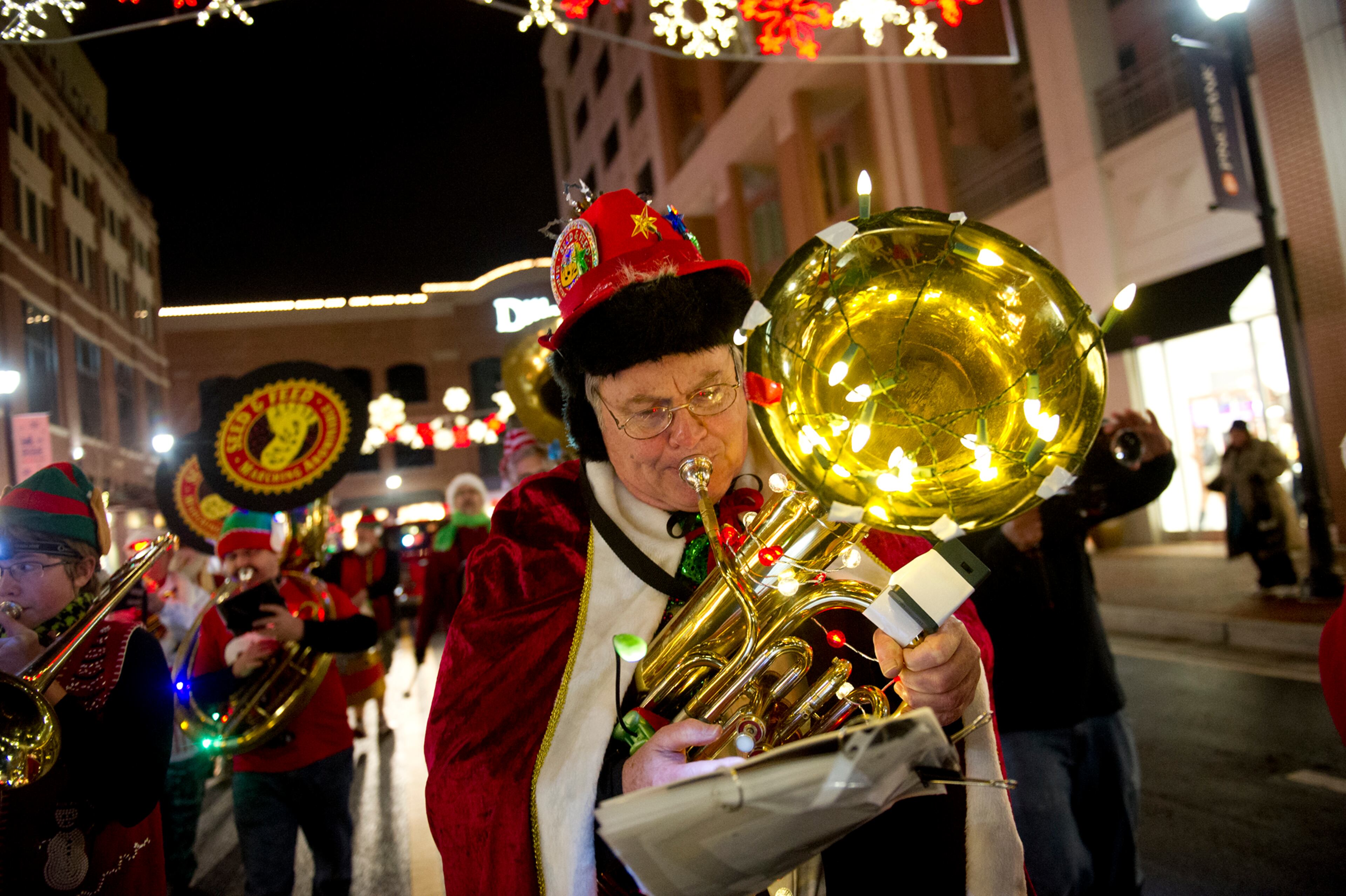 Bob Dorff plays his instrument as he marches down the street at Atlantic Station in Atlanta during the annual Christmas tree lighting on Nov. 23, 2013.