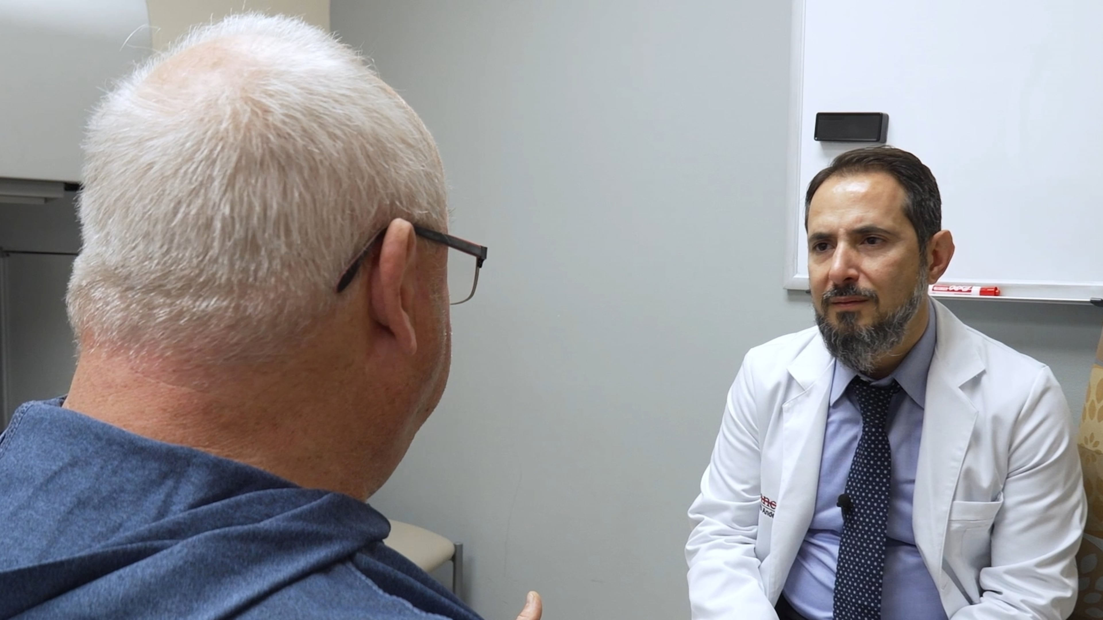 In this image made from video, Tony Hout, left, talks with Dr. Hussein Tawbi at UT MD Anderson Cancer Center in Houston, Monday, Oct. 19, 2026. (AP Photo/Lekan Oyekanmi)