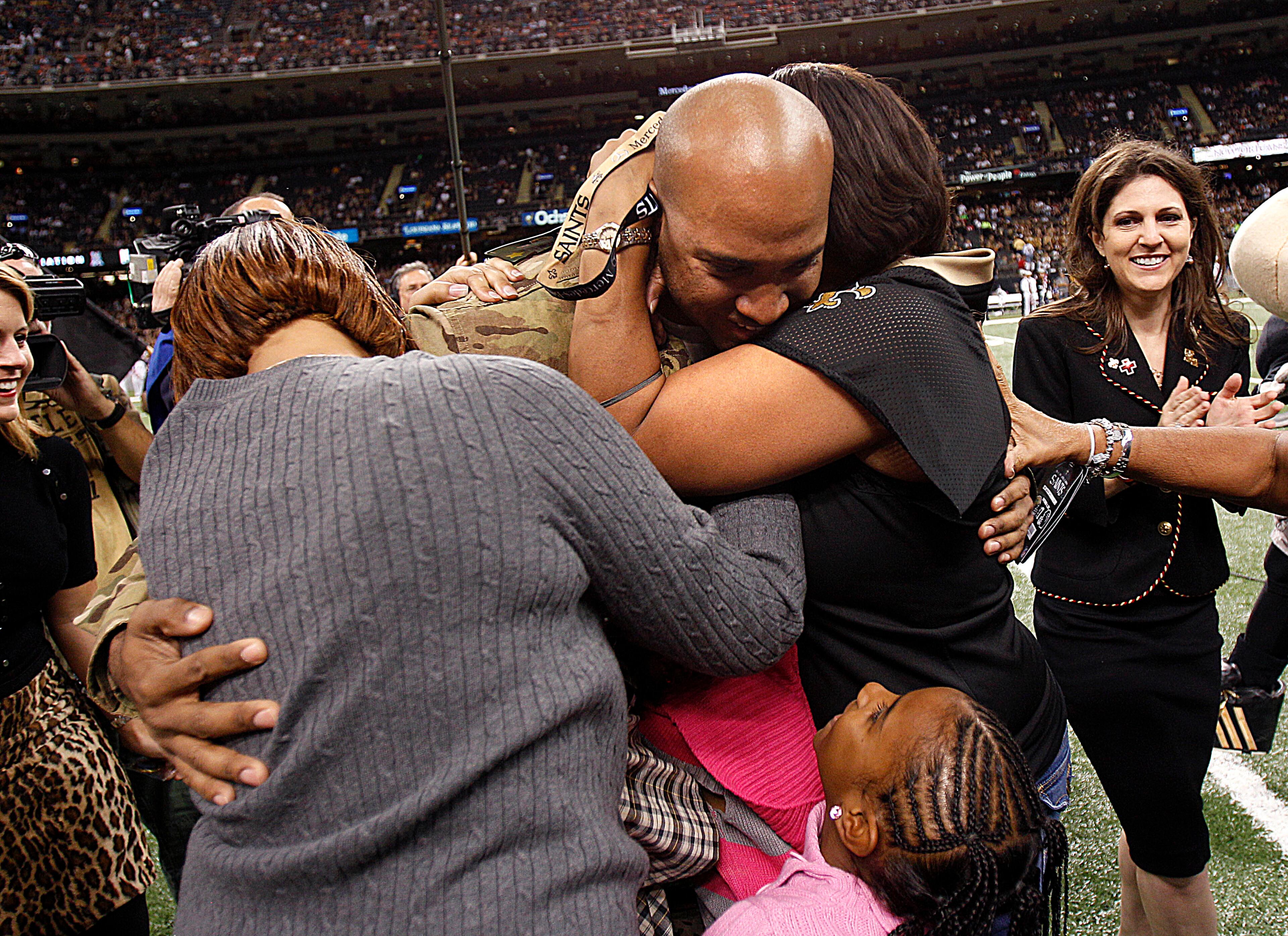 Louisiana National Guard Specialist Brandon Davis is surprised by being reunited with his wife Leslie and four children after a nine month tour in Afghanistan. He has not met his three month old child Isiah, before the NFL football game between the New Orleans Saints and the Atlanta Falcons at the Mercedes-Benz Superdome in New Orleans, Sunday, Nov. 11, 2012. His other children are Micah, Asia and Aliyah. (AP Photo/Bill Haber)