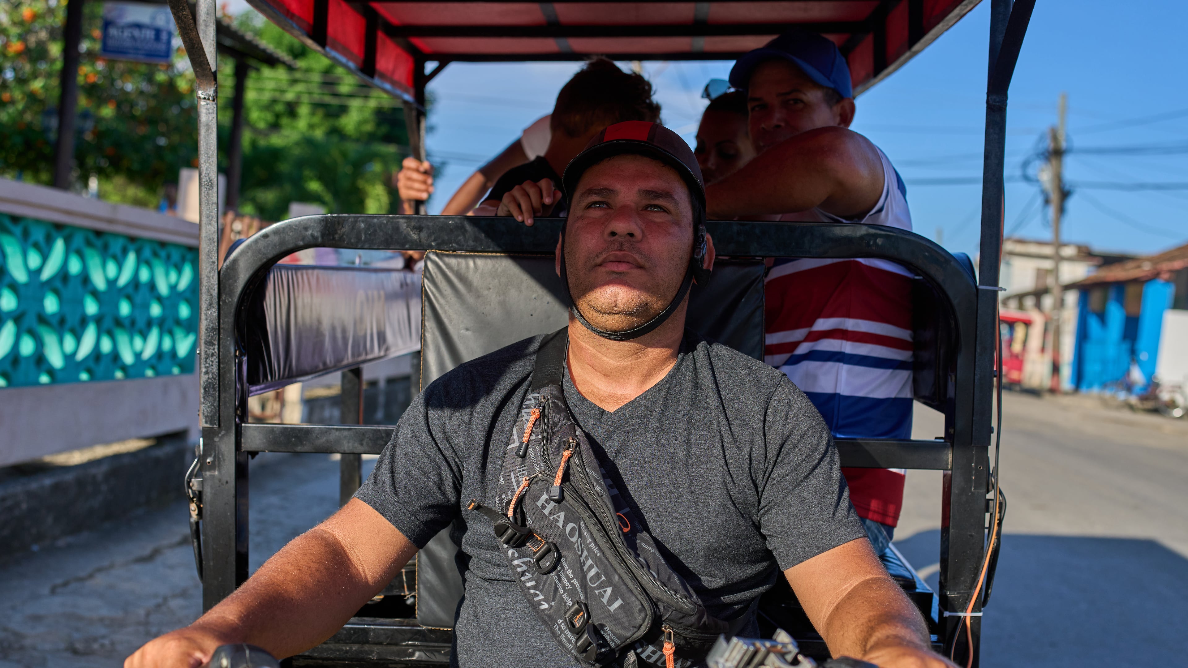 Liexer De La Cruz drives his tricycle with customers in Minas, Cuba's Havana province, Friday, Sept. 4, 2026. (AP Photo/Ramon Espinosa)