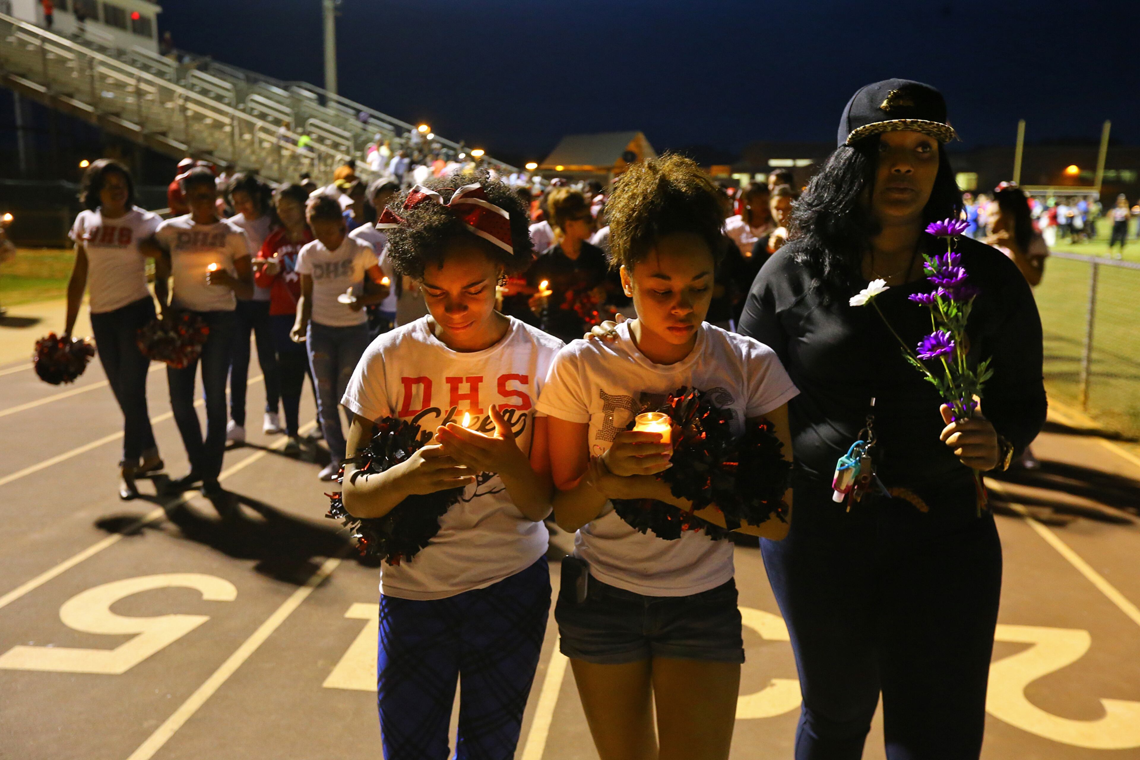 Cheerleaders lead a candle-light vigil on a lap around the track at the conclusion of a vigil to remember 16-year-old Henry County girl Jasmine Poole in the football stadium at Dutchtown High School on Thursday, May 8, 2014, in Hampton. Poole, who was a cheerleader at the school, was killed and two other teens injured in a Wednesday afternoon wreck. CURTIS COMPTON / CCOMPTON@AJC.COM