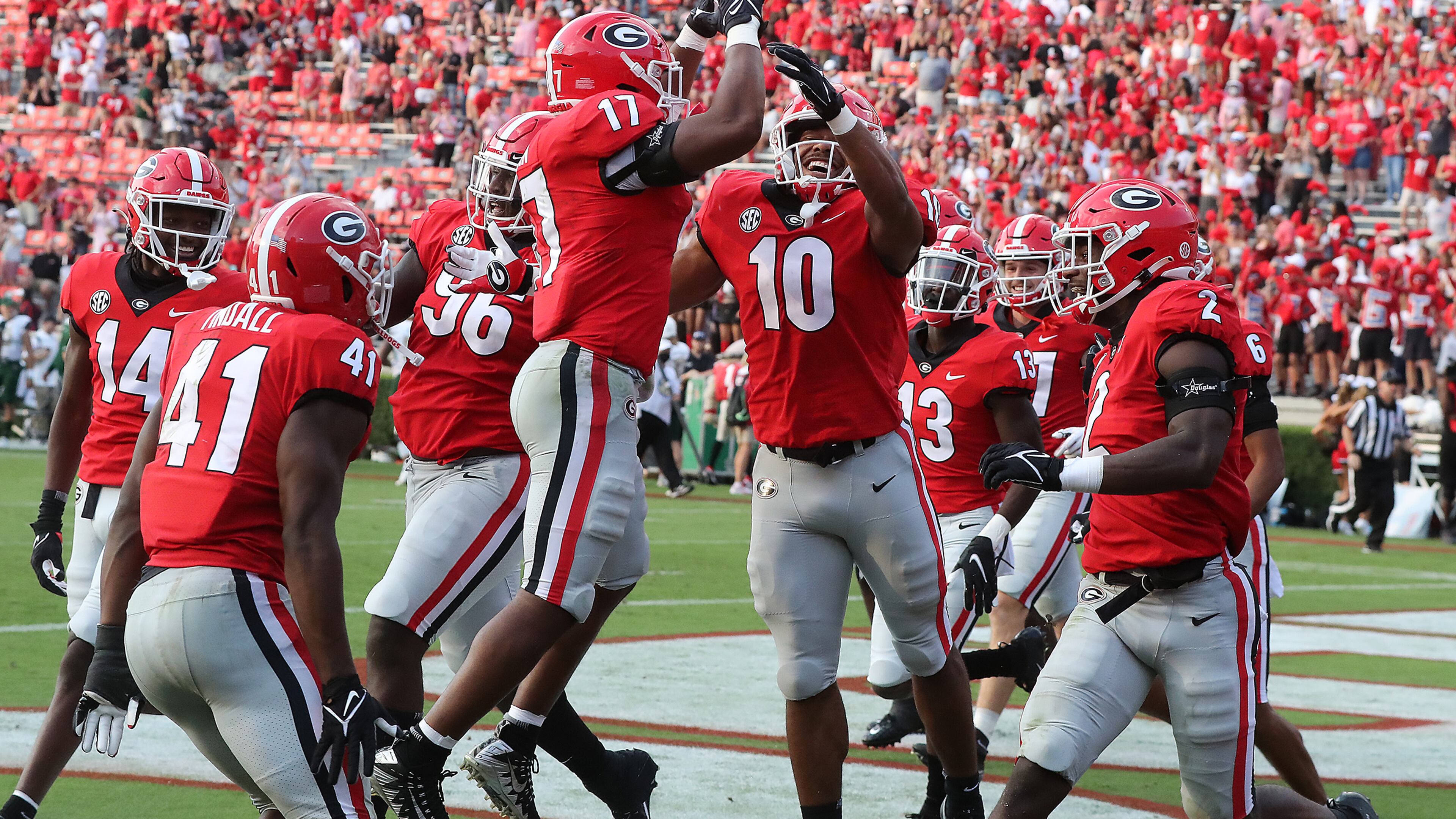 Georgia linebacker (10) Jamon Dumas-Johnson (right) gets some air celebrating his interception return with inside linebacker Nakobe Dean (left) and teammates for a 56-0 lead over UAB during the fourth quarter Saturday, Sept 11, 2021, in Athens. “Curtis Compton / Curtis.Compton@ajc.com”