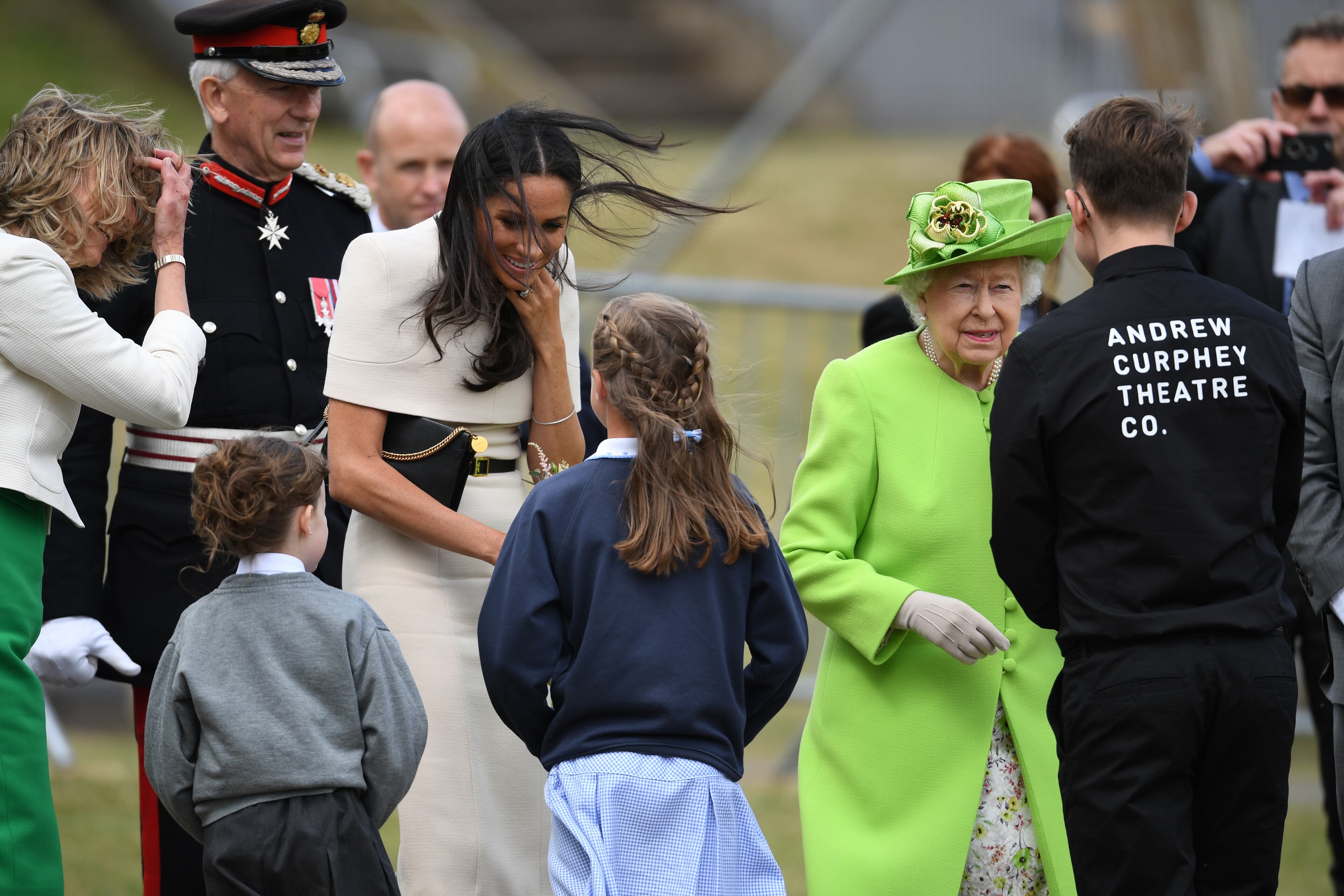 WIDNES, ENGLAND - JUNE 14: Queen Elizabeth II looks on as Meghan, Duchess of Sussex receives flowers as she arrives to open the new Mersey Gateway Bridge on June 14, 2018 in the town of Widnes in Halton, Cheshire, England. Meghan Markle married Prince Harry last month to become The Duchess of Sussex and this is her first engagement with the Queen. During the visit the pair will open a road bridge in Widnes and visit The Storyhouse and Town Hall in Chester. (Photo by Jeff J Mitchell/Getty Images)