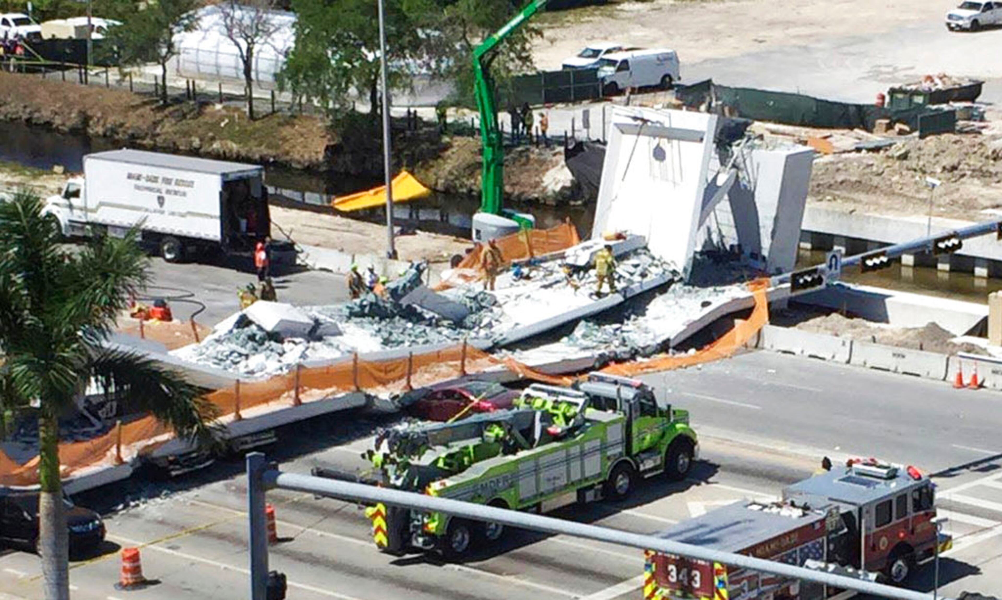Emergency personnel respond to a collapsed pedestrian bridge at Florida International University on Thursday, March 15, 2018, in the Miami area. The brand-new pedestrian bridge collapsed onto a highway crushing several vehicles. (Roberto Koltun/Miami Herald via AP)