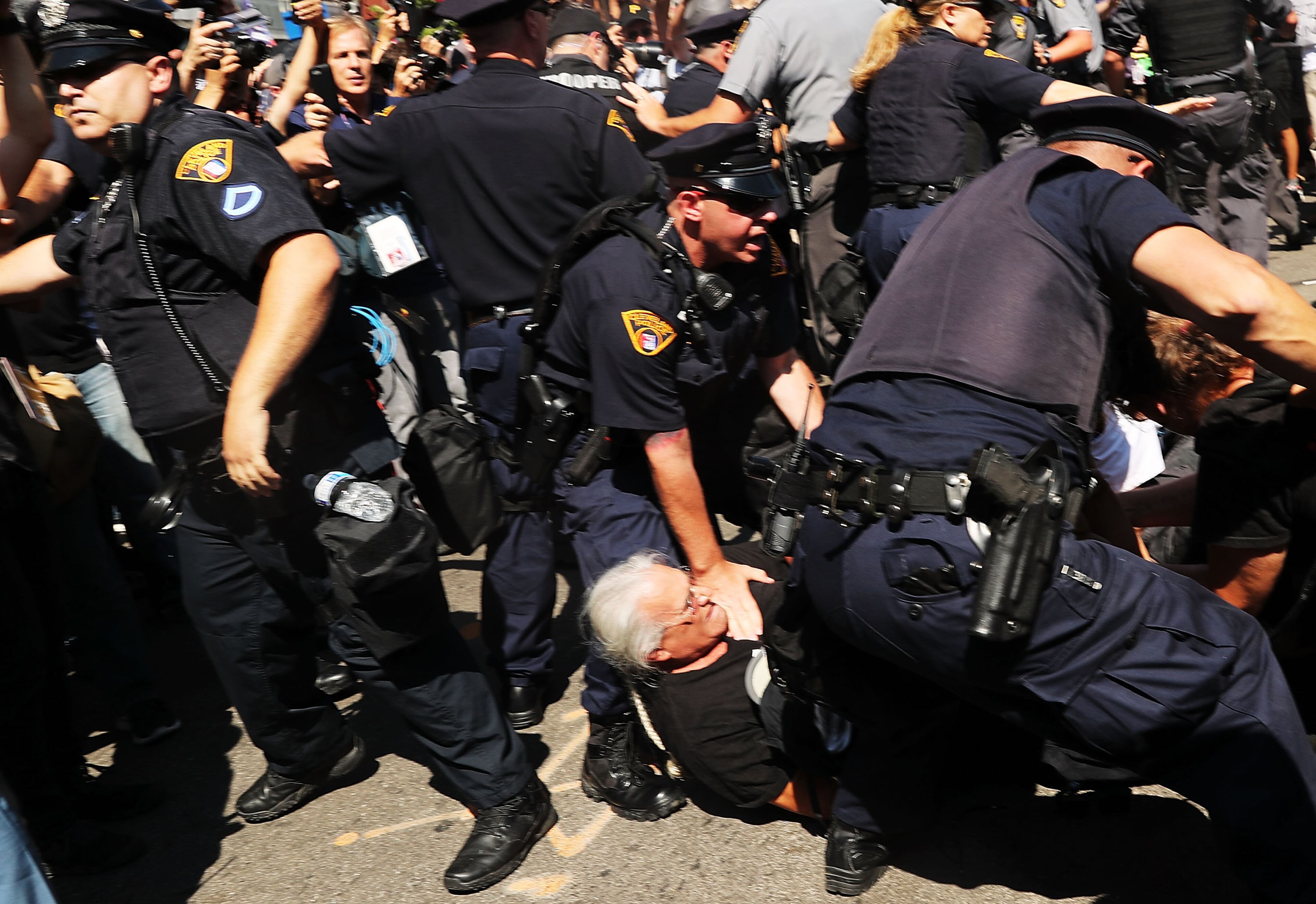 Protesters struggle with police after trying to burn an American Flag near the sight of the Republican National Convention (RNC) in downtown Cleveland on the third day of the convention on July 20, 2016 in Cleveland, Ohio. Many people have stayed away from downtown due to road closures and the fear of violence. An estimated 50,000 people are expected in Cleveland, including hundreds of protesters and members of the media. The four-day Republican National Convention kicked off on July 18. (Photo by Spencer Platt/Getty Images)