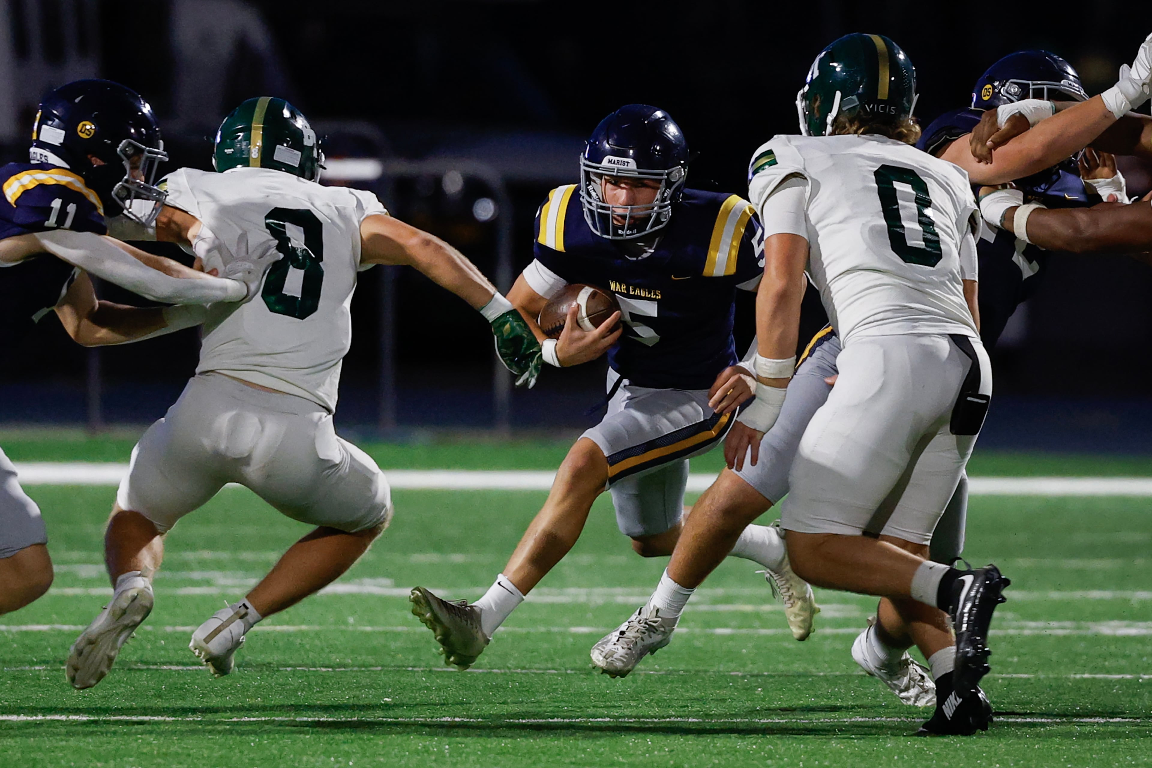 Blessed Trinity defenders Bishop Dameron (0) and Brady Hester (8) stop Marist quarterback Hayes Rollauer (5) during the first half a high school football game between Blessed Trinity and Marist, Friday, Sept. 25, 2026, in Atlanta. (Erik S. Lesser for the AJC)