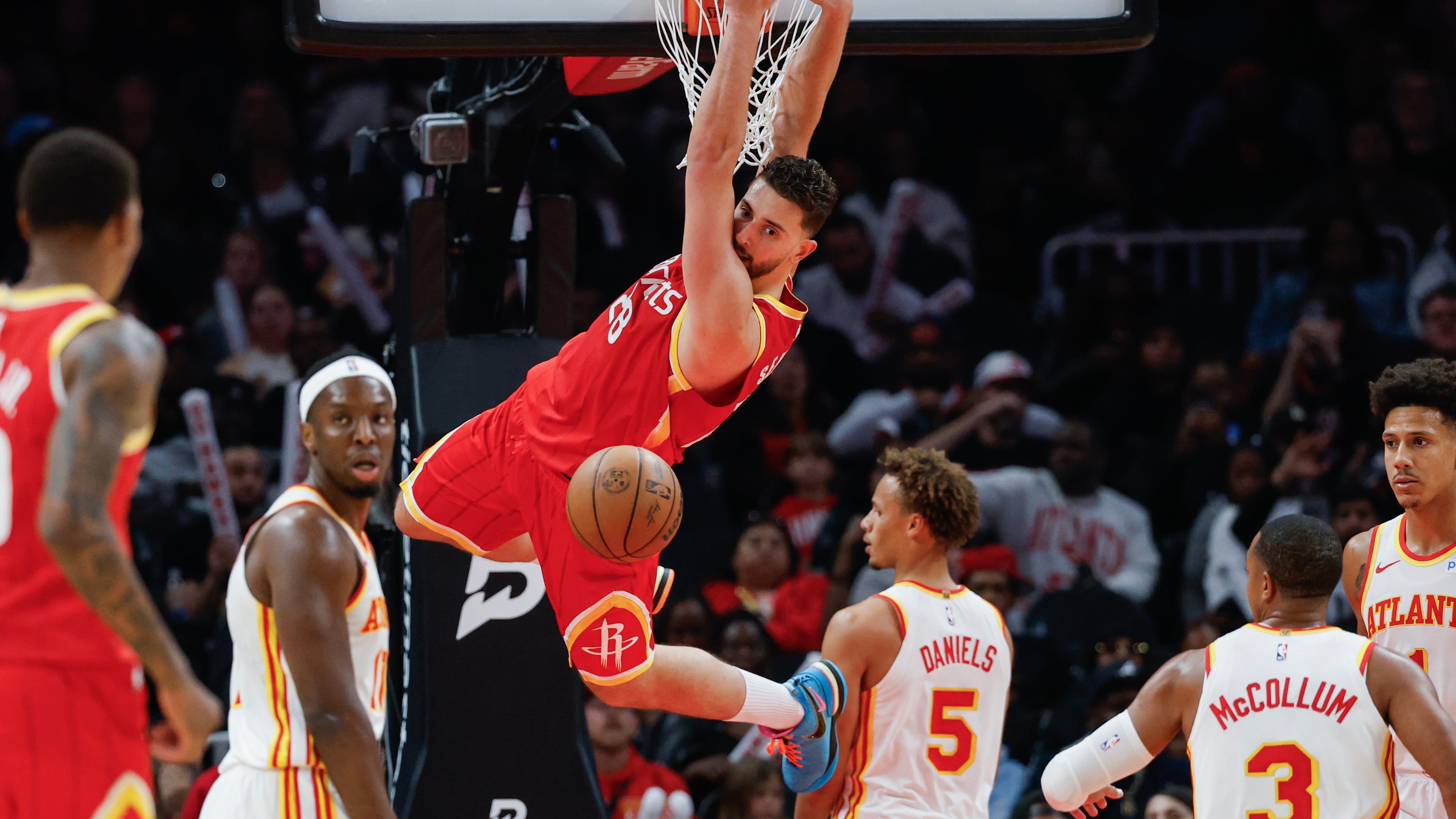 Houston Rockets center Alperen Sengun (28) hangs from the rim after dunking against Atlanta Hawks guard Dyson Daniels (5) during the second half of an NBA basketball game, Saturday, Oct. 24, 2026, in Atlanta. (Erik S. Lesser/AP)