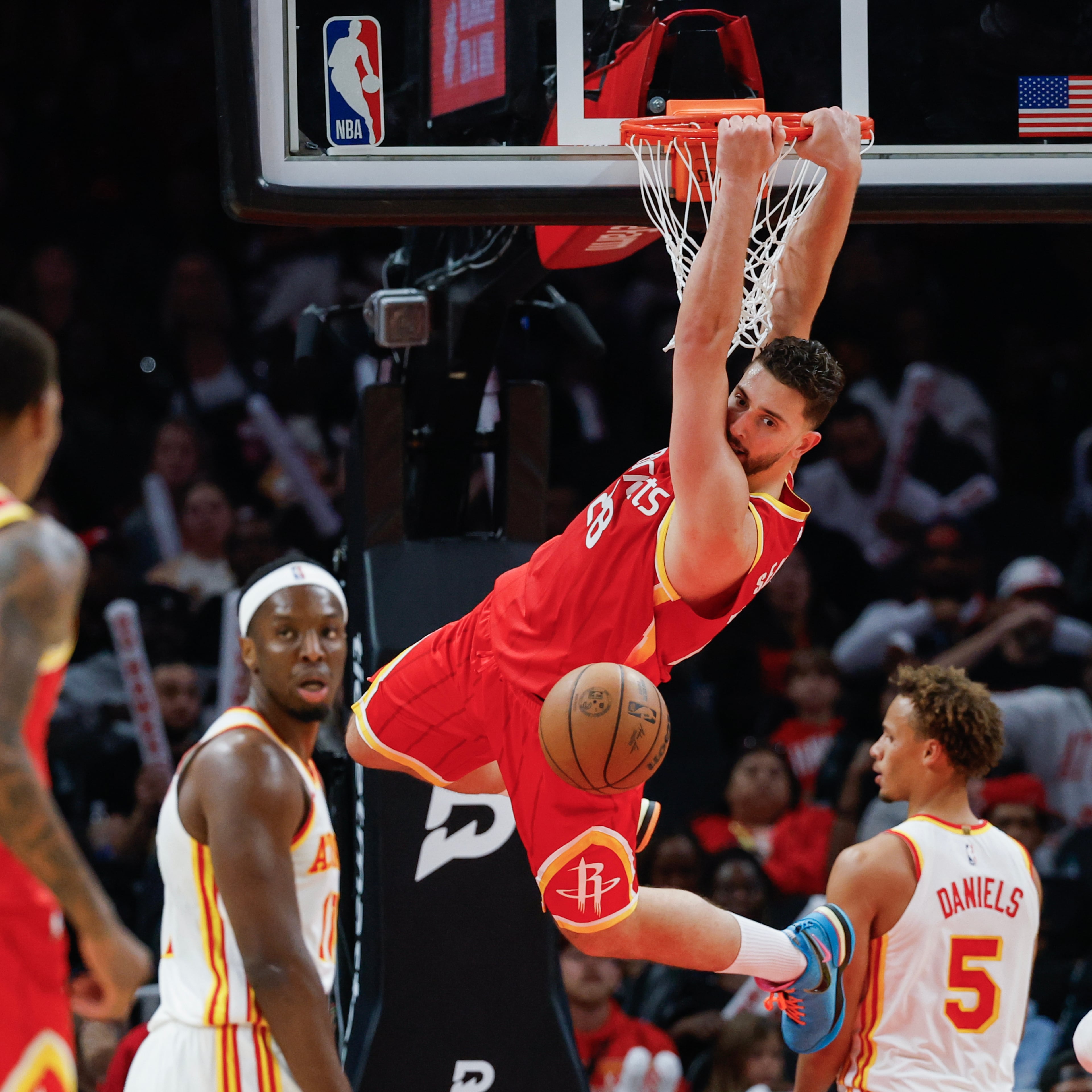 Houston Rockets center Alperen Sengun (28) hangs from the rim after dunking against Atlanta Hawks guard Dyson Daniels (5) during the second half of an NBA basketball game, Saturday, Oct. 24, 2026, in Atlanta. (Erik S. Lesser/AP)
