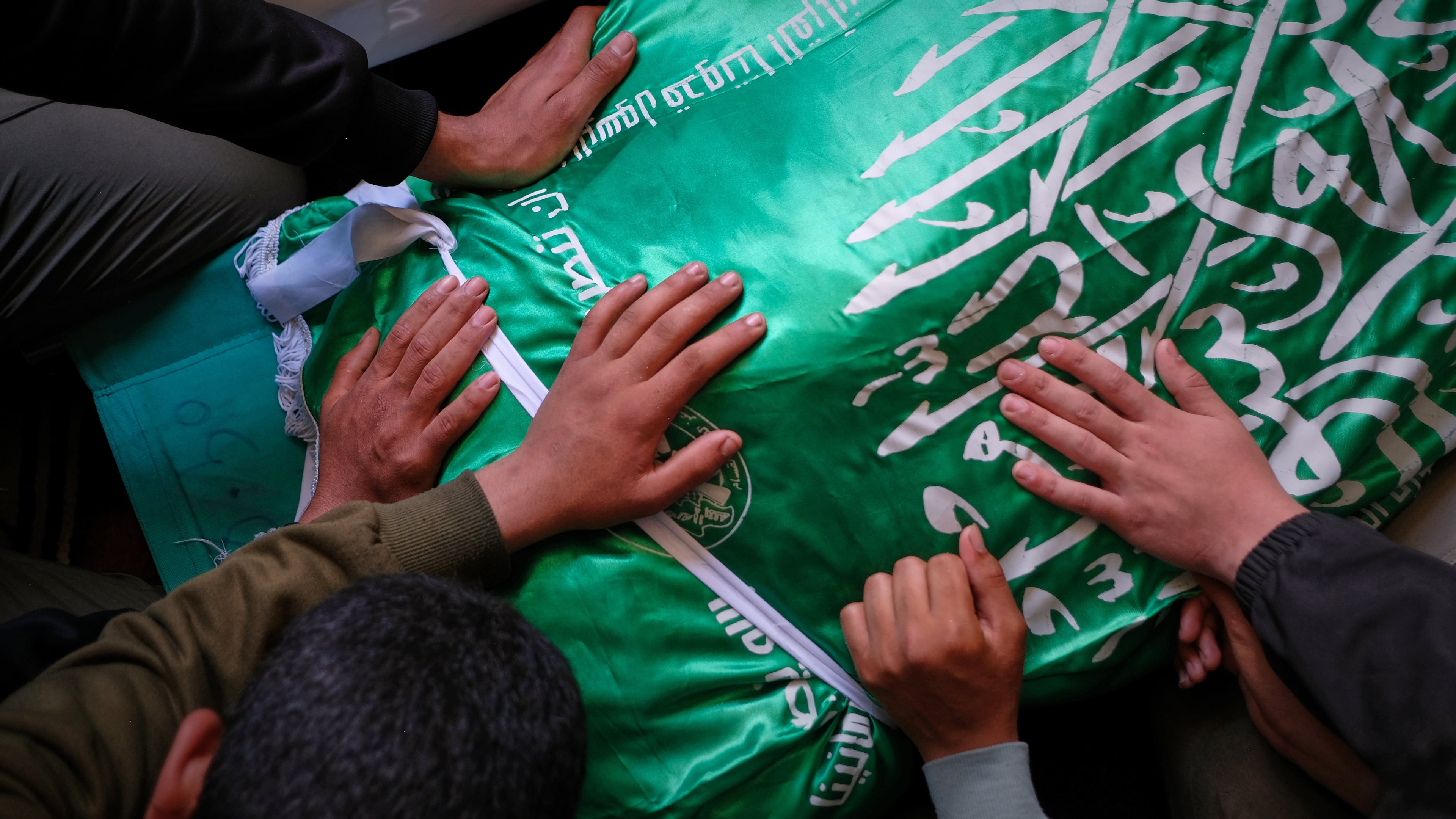 Palestinians place their hands on the body of Izz al-Din al-Haddad, the leader of Hamas' Qassam Brigades, draped in a Hamas flag during his funeral in Gaza City, Saturday, May 16, 2026. (AP Photo/Jehad Alshrafi)