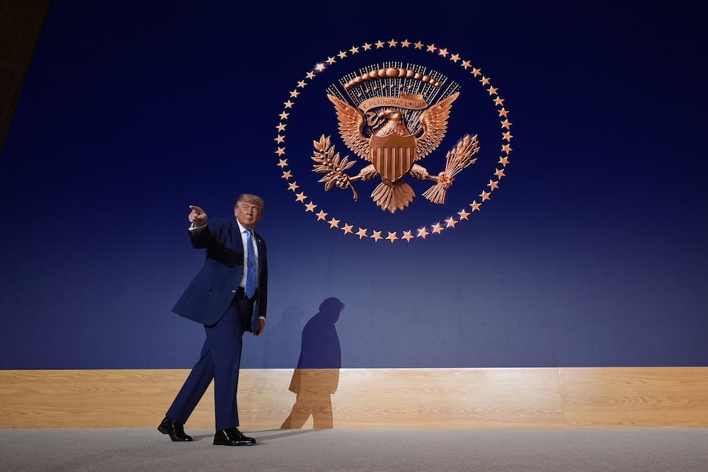 President Donald Trump walks across the stage at the Andrew W. Mellon Auditorium on Tuesday in Washington. (Alex Brandon/AP)