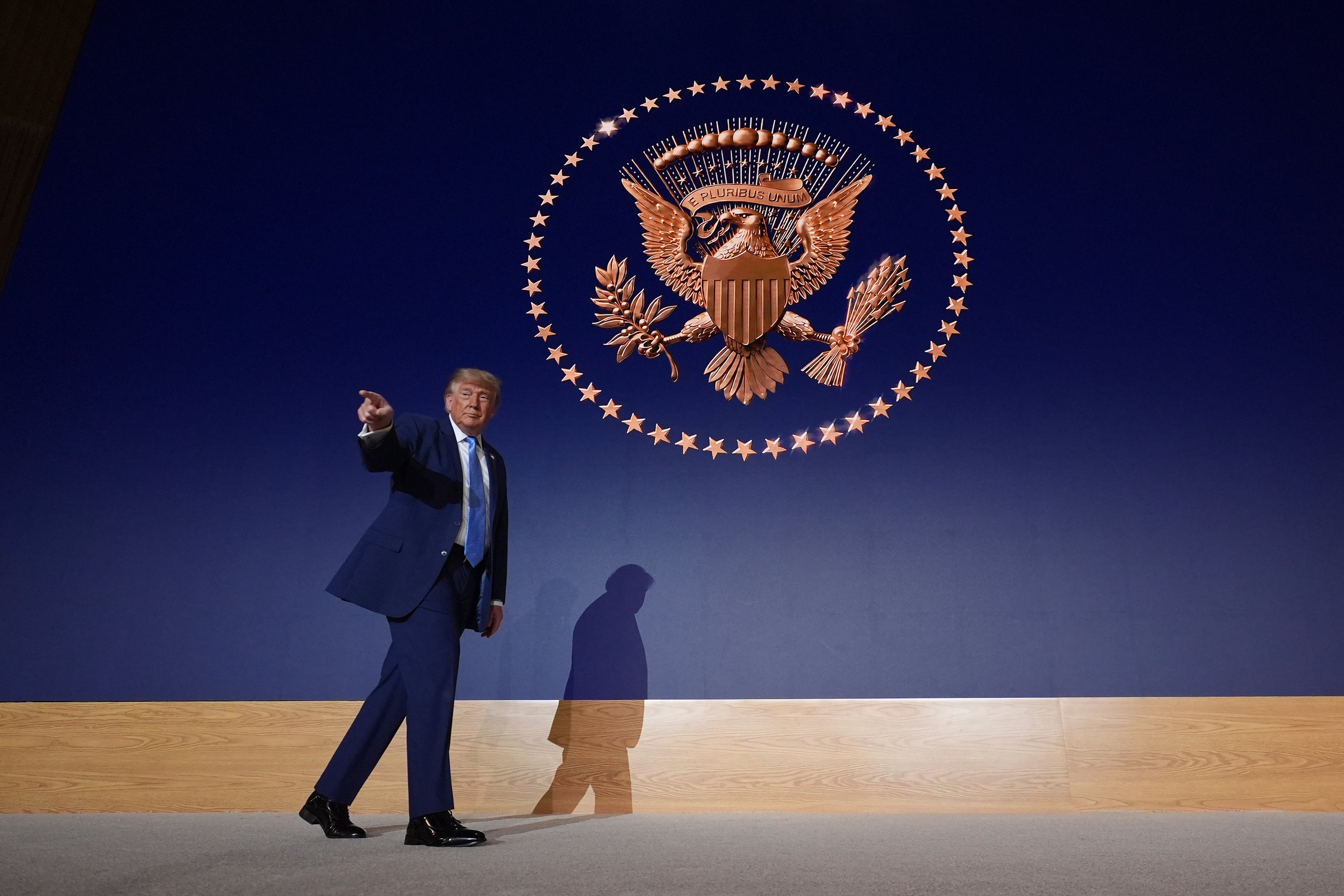 President Donald Trump walks across the stage at the Andrew W. Mellon Auditorium on Tuesday in Washington. (Alex Brandon/AP)