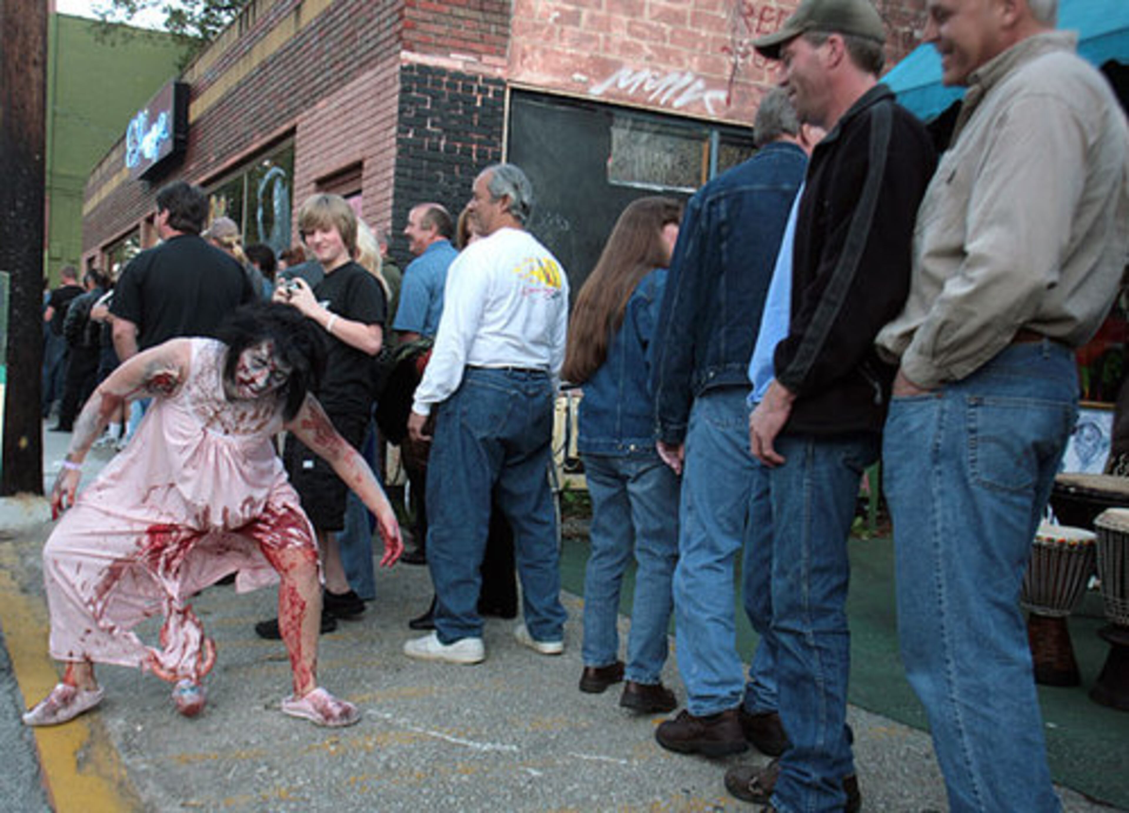 Kelly Hutto tries to disturb people waiting in line outside the Variety Playhouse in Little Five Points. More than 300 people dressed as zombies walked from Masquerade on North Avenue, turned south on Moreland Avenue and finished up in Little Five Points.